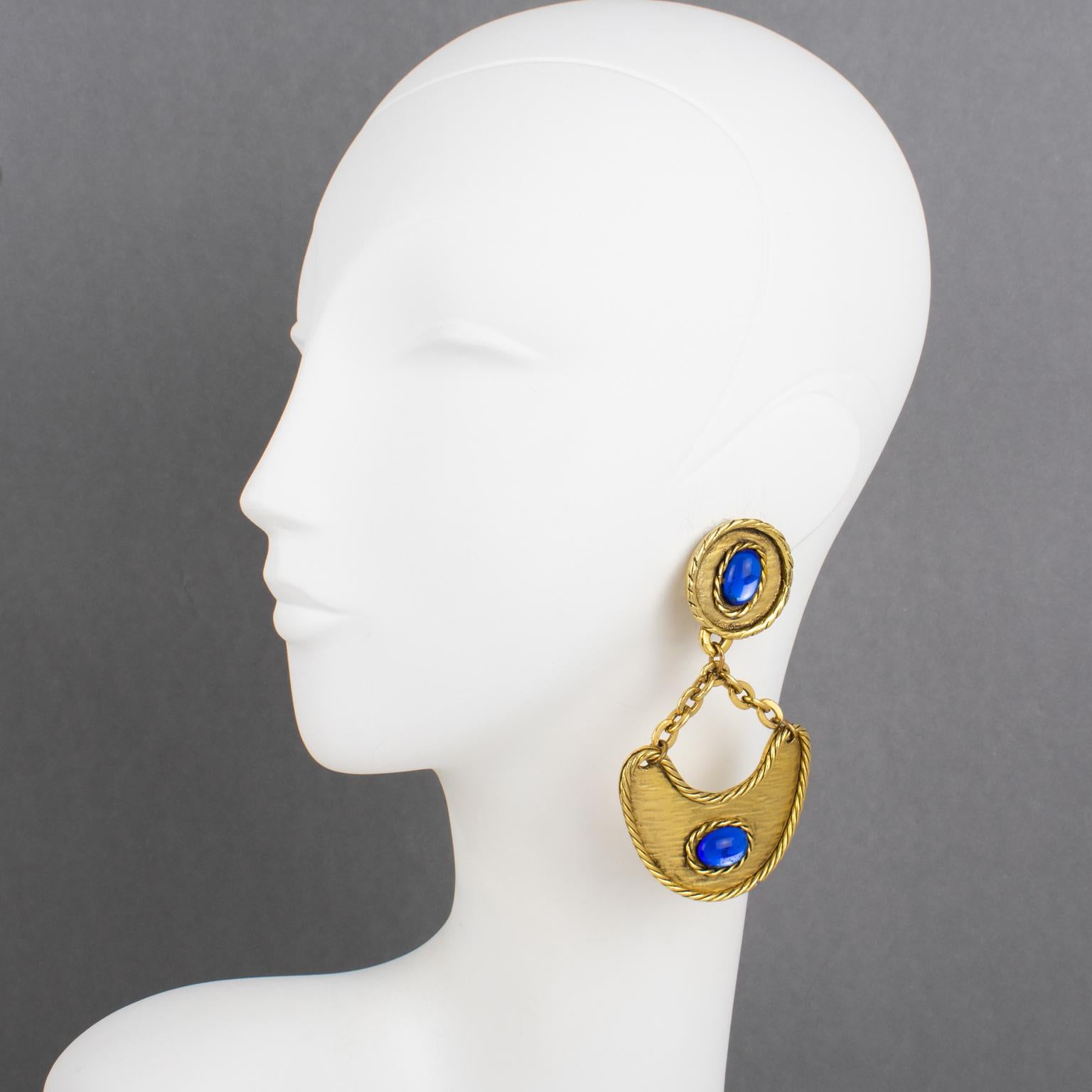 These Ultra-chic dangling clip-on earrings have a design reminiscent of Mercedes Robirosa's work. The earrings are a stunning example of baroque style, with a massive construction that captures attention. Its gilt metal frame adds a touch of