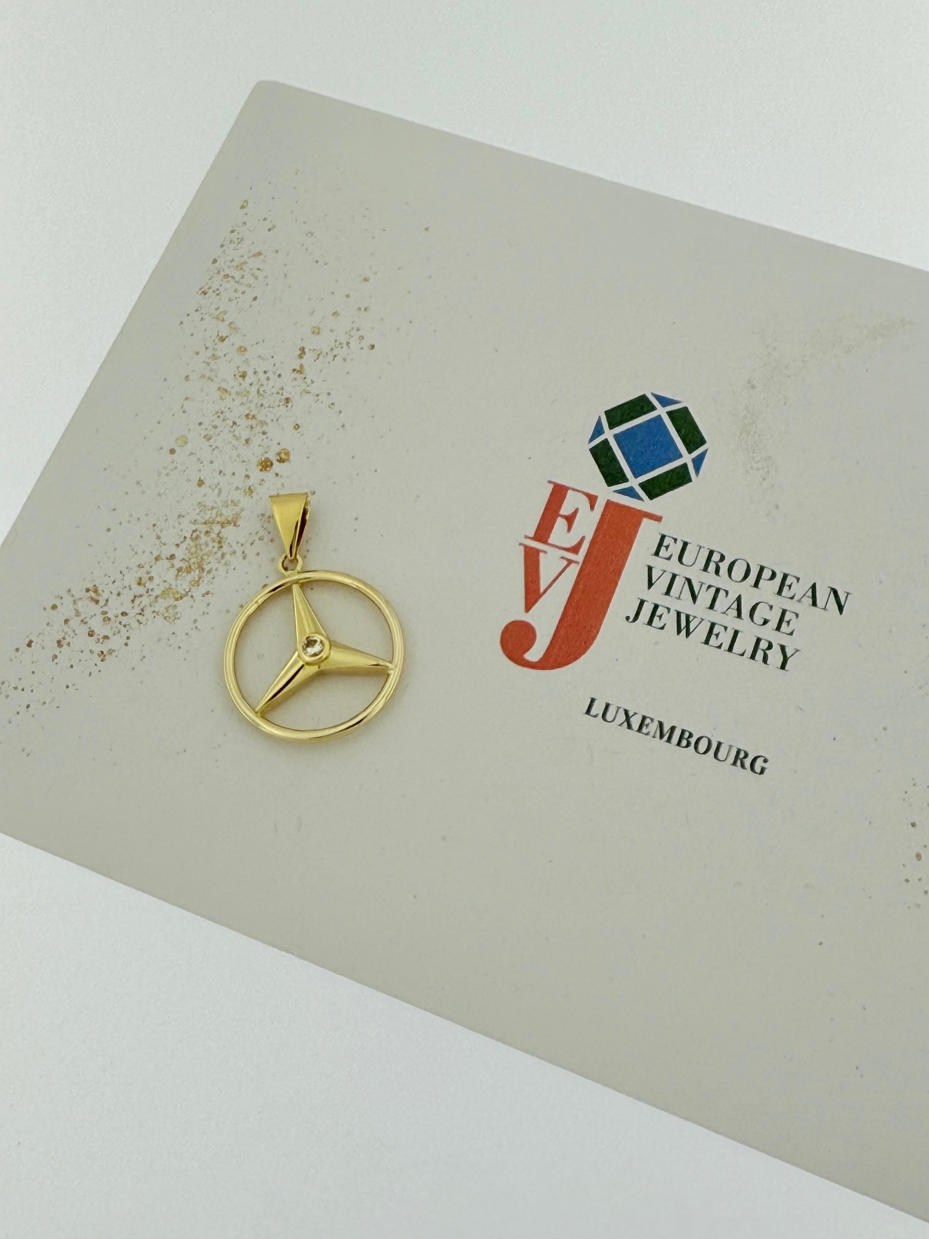 Cet élégant pendentif Mercedes est finement réalisé en or jaune 18 carats et présente un design élégant et intemporel inspiré de l'emblème Mercedes. En son centre repose un diamant naturel de taille brillant d'environ 0,10 carats, serti en chaton