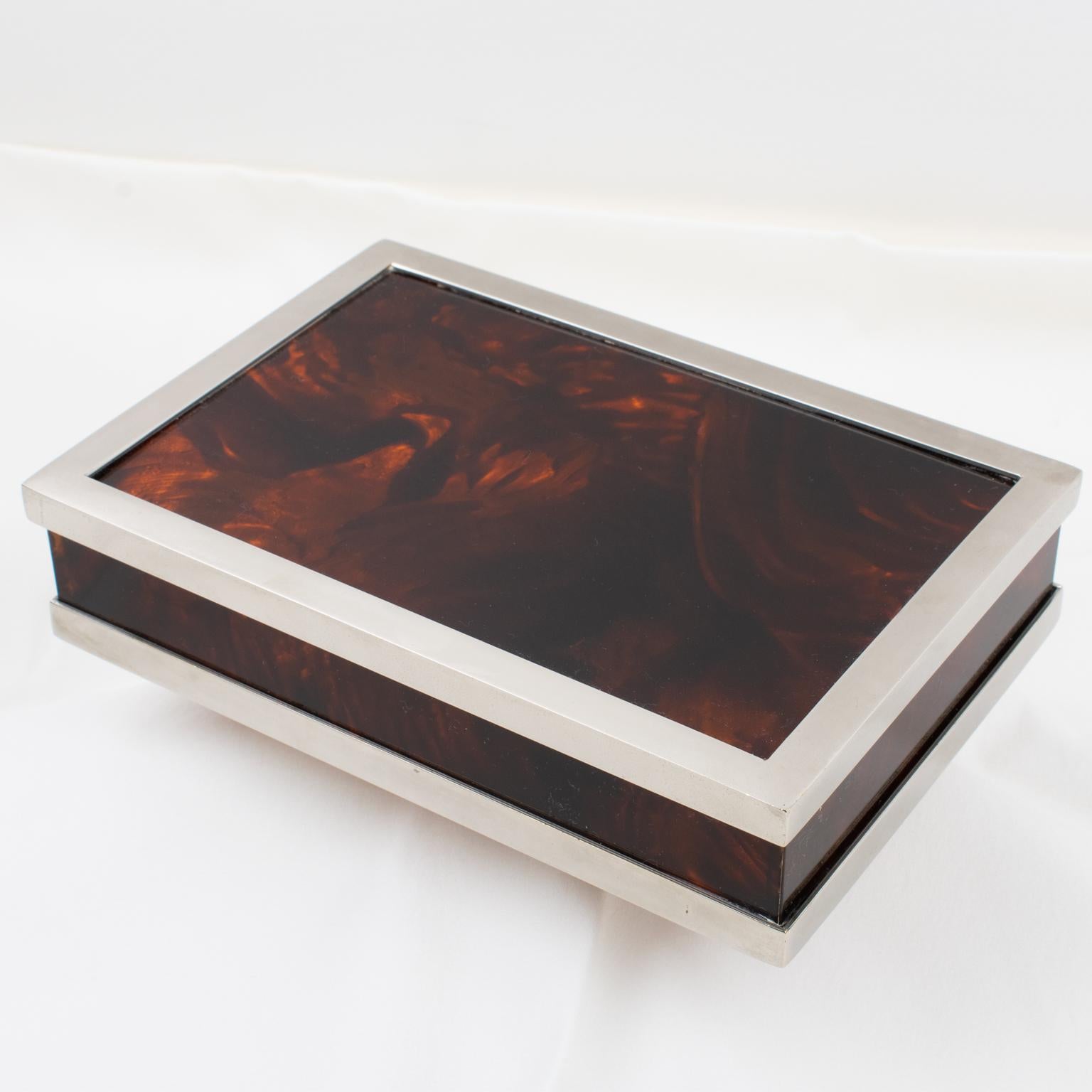La casa de lujo parisina Maison Mercier Freres diseñó esta elegante caja decorativa con tapa. La pieza se fabricó en Francia hacia 1970. Presume de una forma rectangular de diseño modernista, con una base gruesa de Lucite o resina con textura de