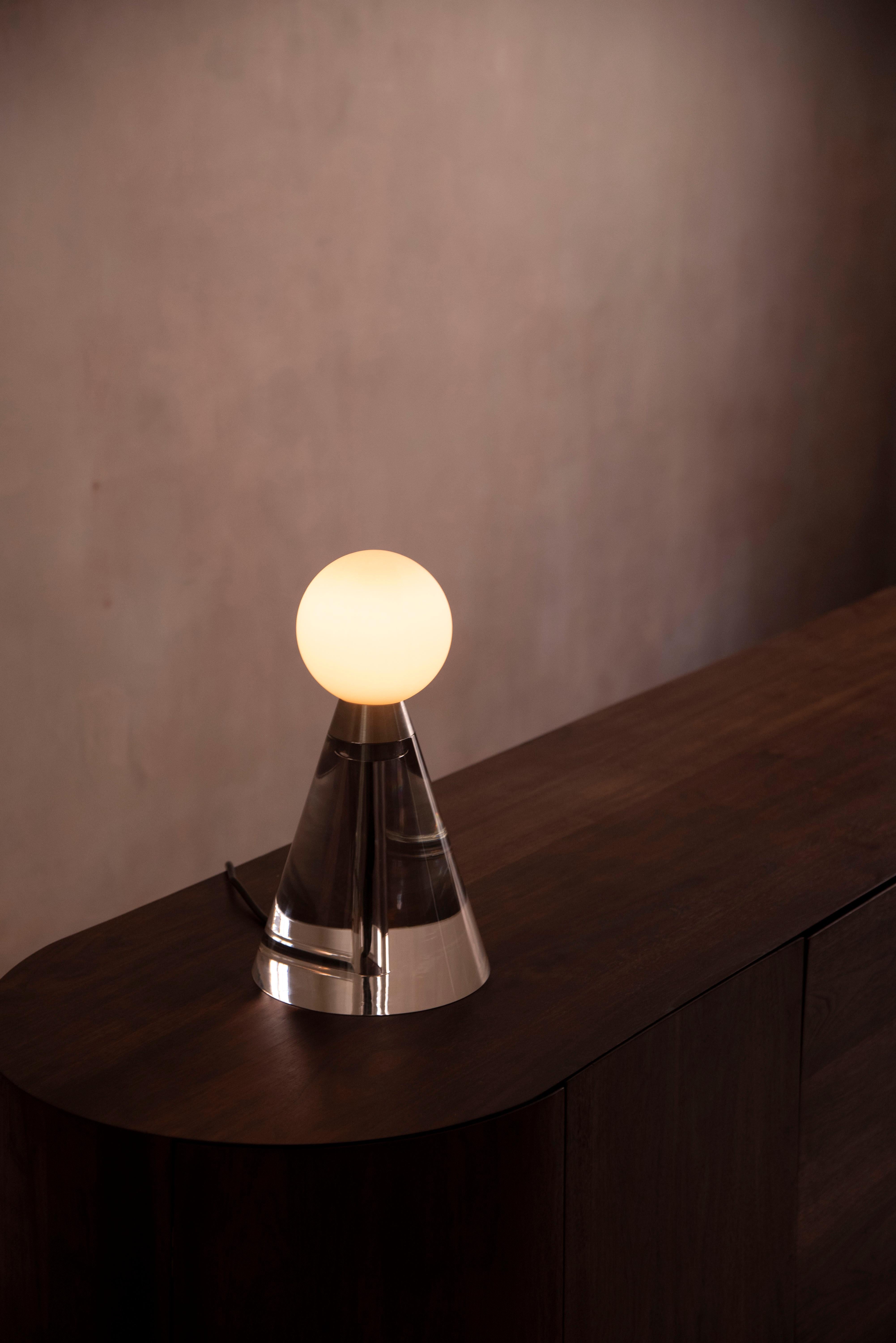Mercurio is a sculptural table lamp characterized by its balanced geometric form and
simplistic appearance. 

The elements of Mercurio form a connection between humans
and our minimal understanding of the universe. The base references totemic
