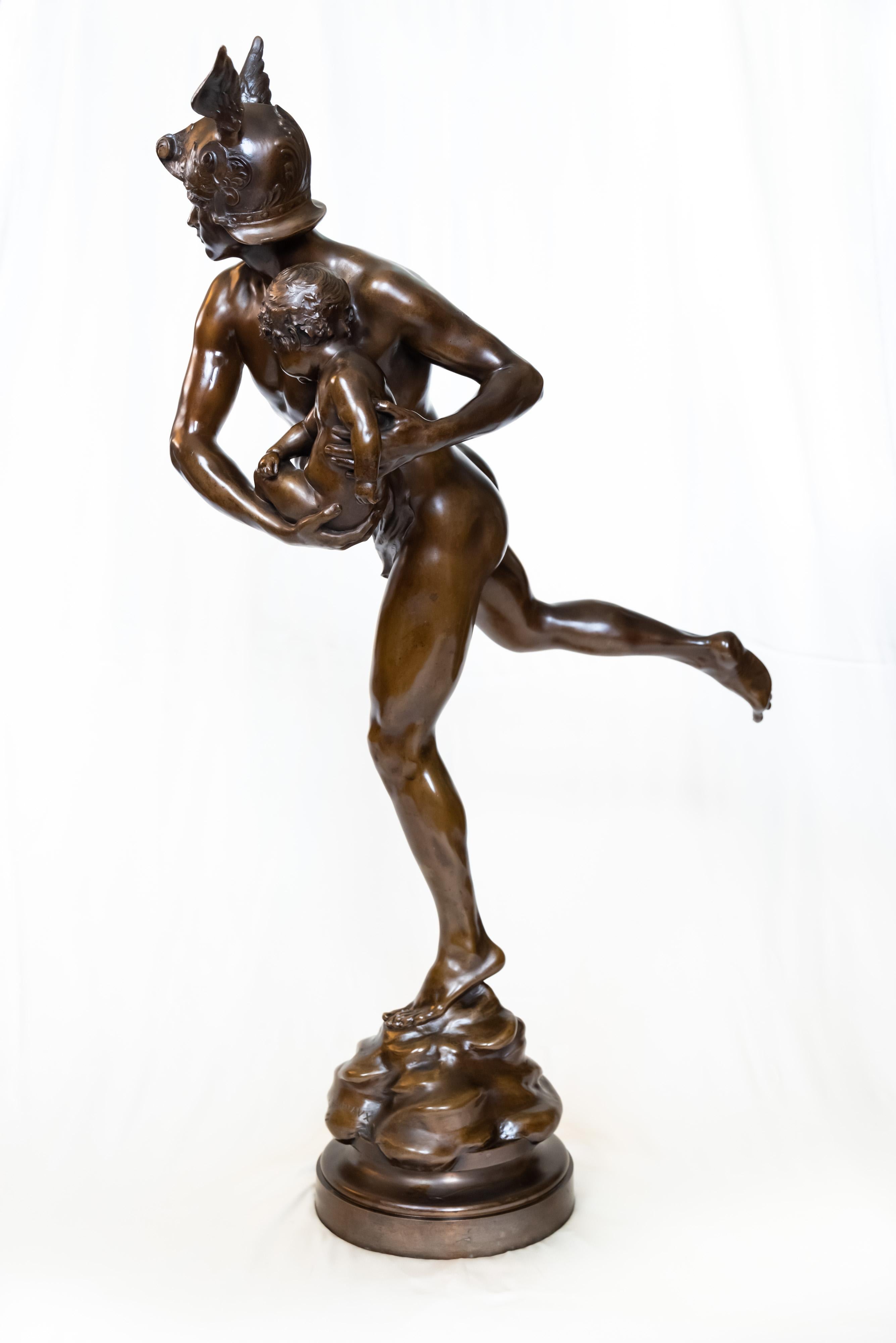 Mercure portant Cupidon - Merkur, der Amor befreit - von dem französischen Bildhauer Emmanuel Hannaux. Die Figur aus schokoladenpatinierter Bronze, die auf einem runden, drehbaren Sockel ruht, strahlt sowohl geschmeidige Eleganz als auch feurige
