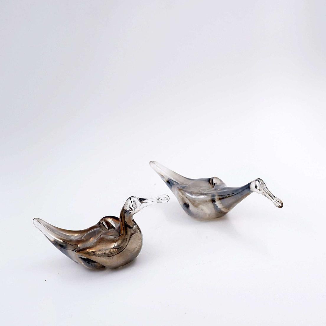 Coppia di anatre in vetro di mercurio
Scultura - Decorazione - Vetro artistico
Misure: 24 cm x 5,5 cm H. 7,5 cm 
                   17cm x 6,5cm H:8,5cm 
Materiale: vetro di mercurio 
Usura coerente con l'età e l'uso.