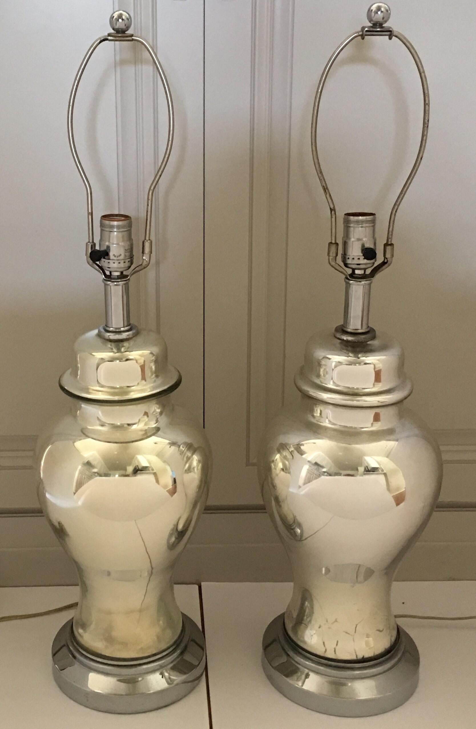 Pair of midcentury mercury glass ginger jar table lamps. These reflective mirror-like lamps are mounted on round nickel plated plinth bases. Beautiful bedside or living room lamps. Lamp shades not included.

Measures: 28 inches high to finial.
21