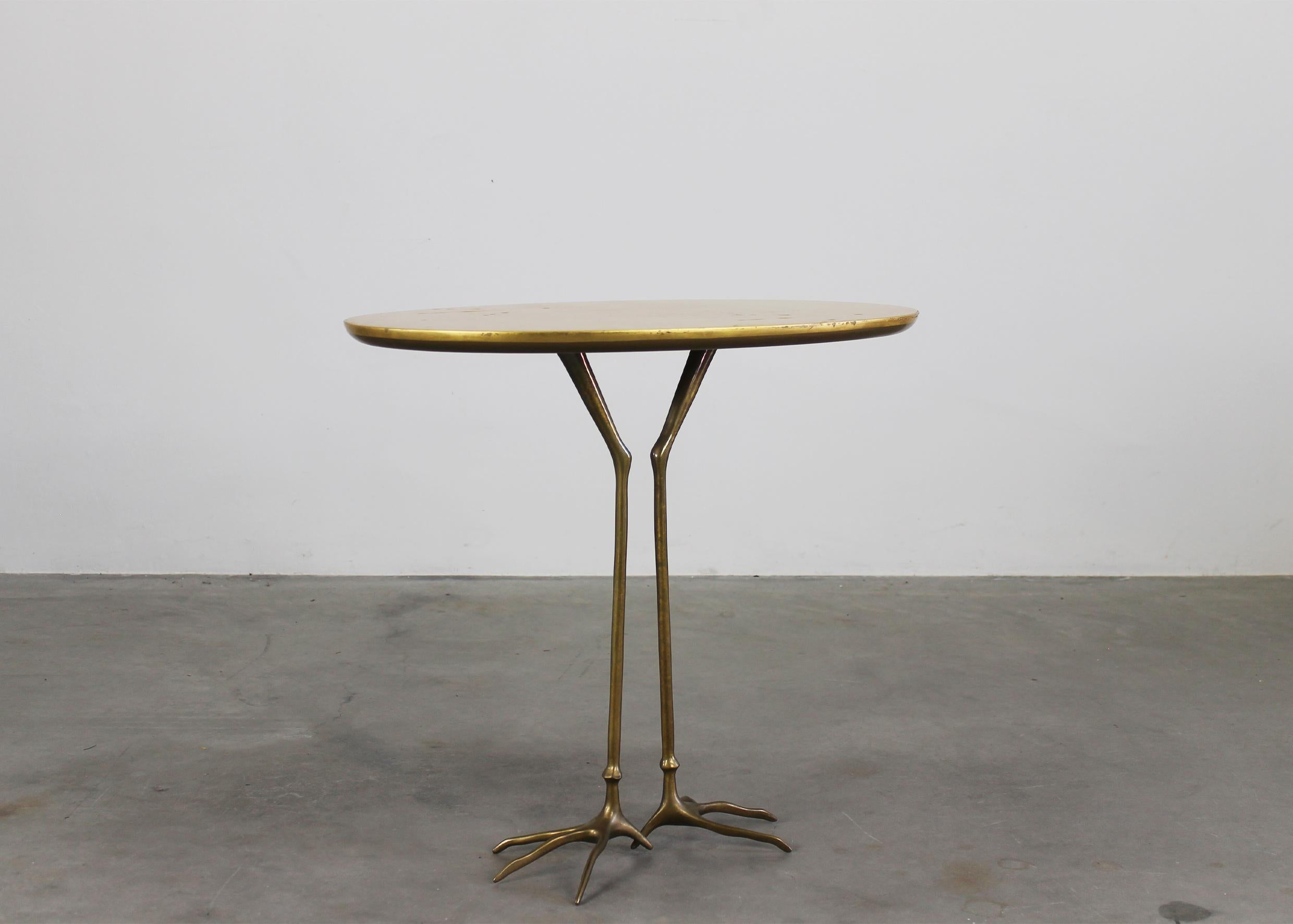 Beistelltisch Traccia mit Struktur aus polierter Gussbronze, elliptische Platte aus Sperrholz mit feinem Blattgold. 

Der Tisch Traccia wurde ursprünglich von Meret Oppenheim 1939 für die Surrealisten-Ausstellung über die Avantgarde-Möbel in Paris