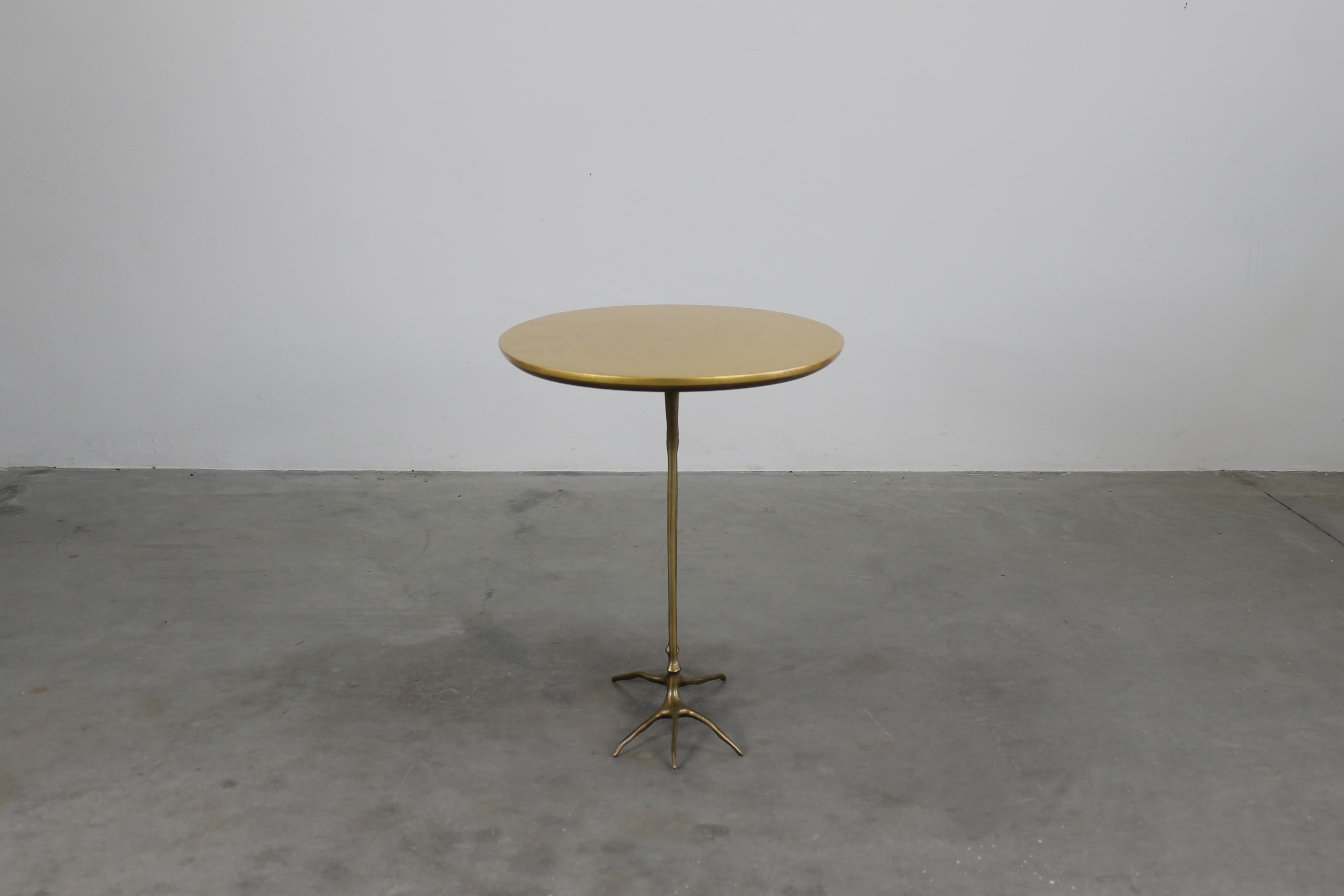 Table d'appoint Traccia avec structure en bronze moulé poli, plateau elliptique en contreplaqué recouvert d'une fine feuille d'or jaune. 

La table Traccia a été conçue à l'origine par Meret Oppenheim en 1939 pour l'exposition surréaliste sur le