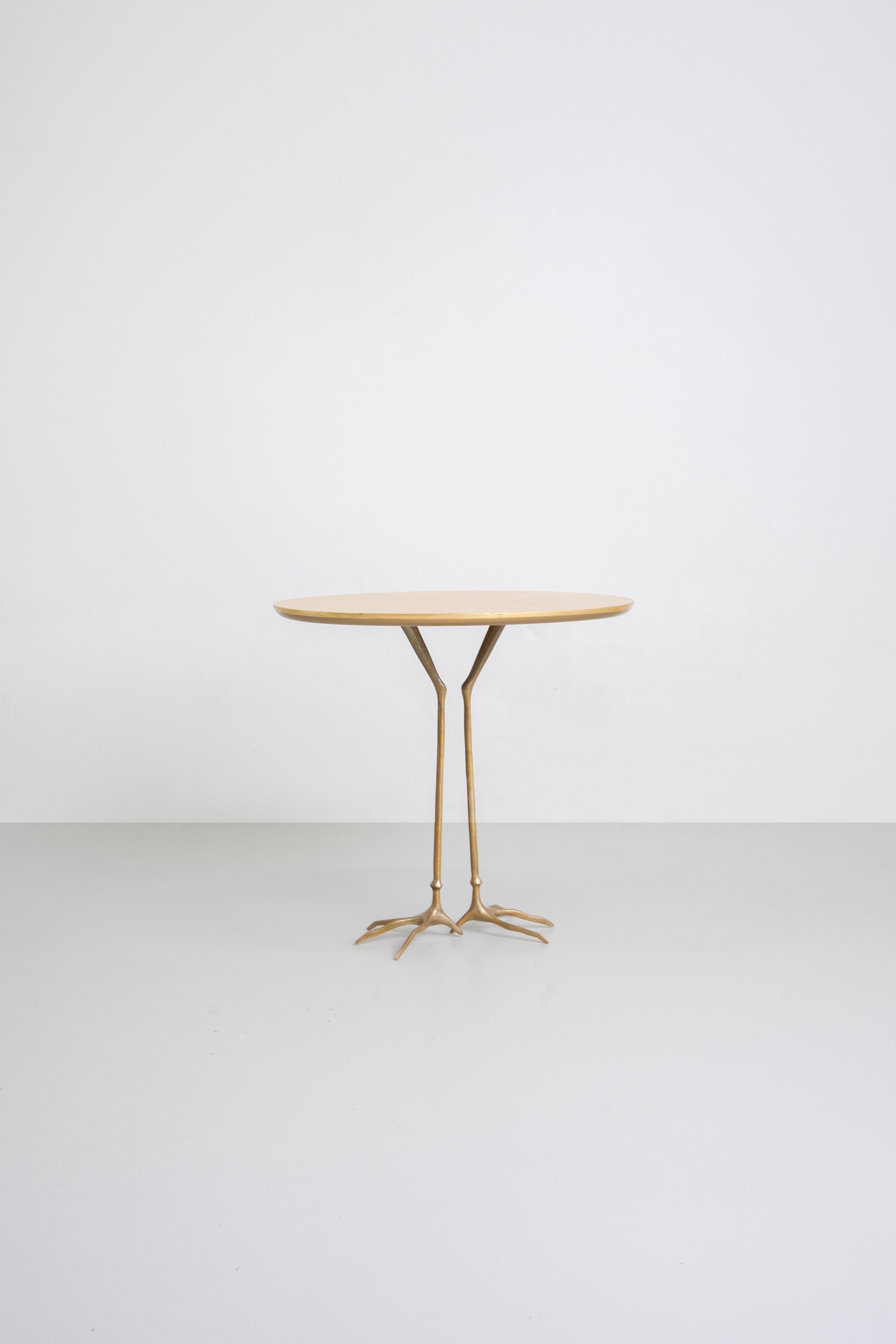 Table d'appoint Traccia avec structure en bronze moulé poli, plateau elliptique en contreplaqué recouvert d'une fine feuille d'or jaune. 

La table Traccia a été conçue à l'origine par Meret Oppenheim en 1939 pour l'exposition surréaliste sur le