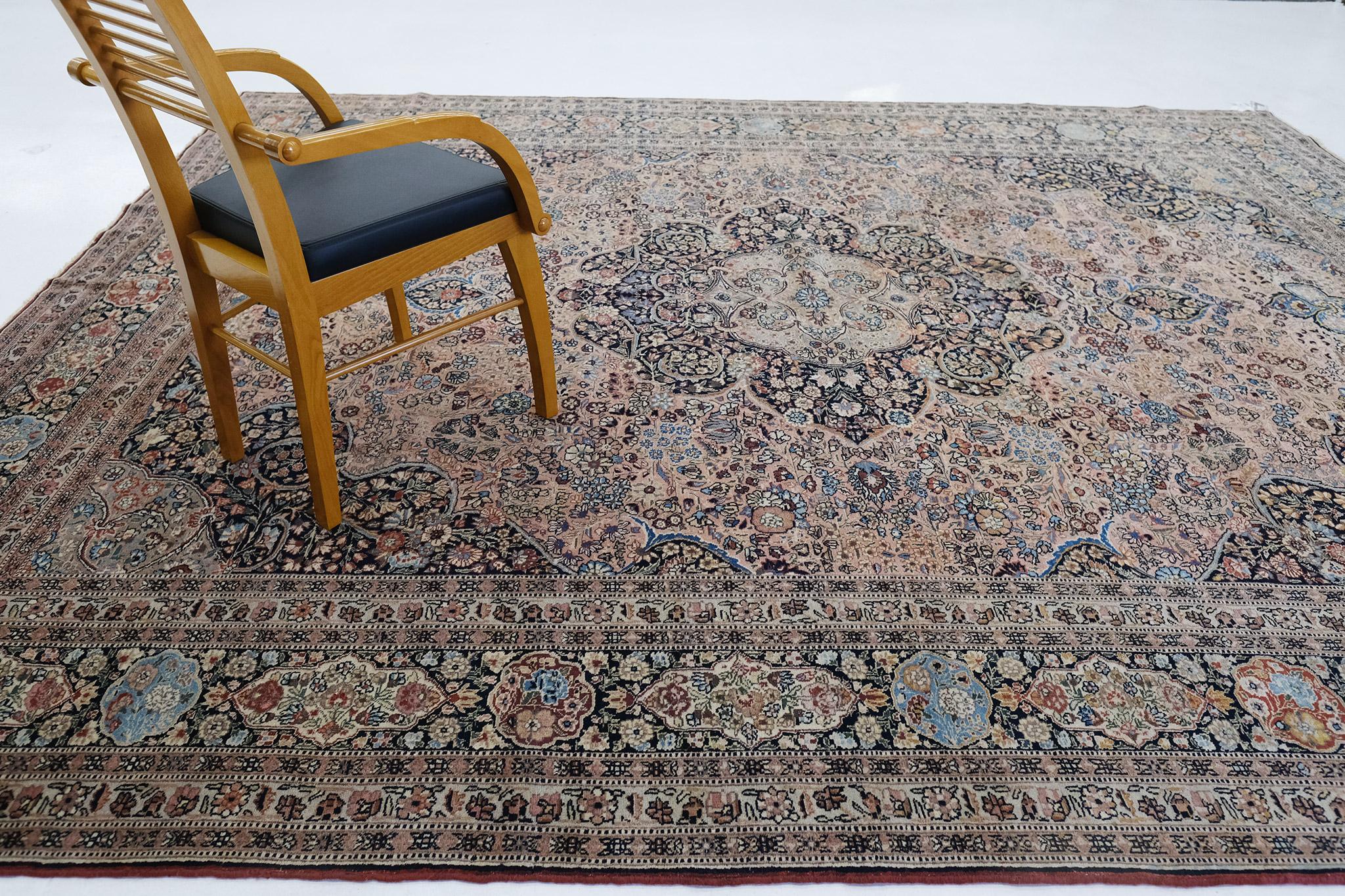 This stunning vintage Tabriz rug has a camel field with a central medallion with spandrels that complements it. The center of the rug features a symmetrical pattern, that contains scrolling vines and split leaves in design, and delicate flower