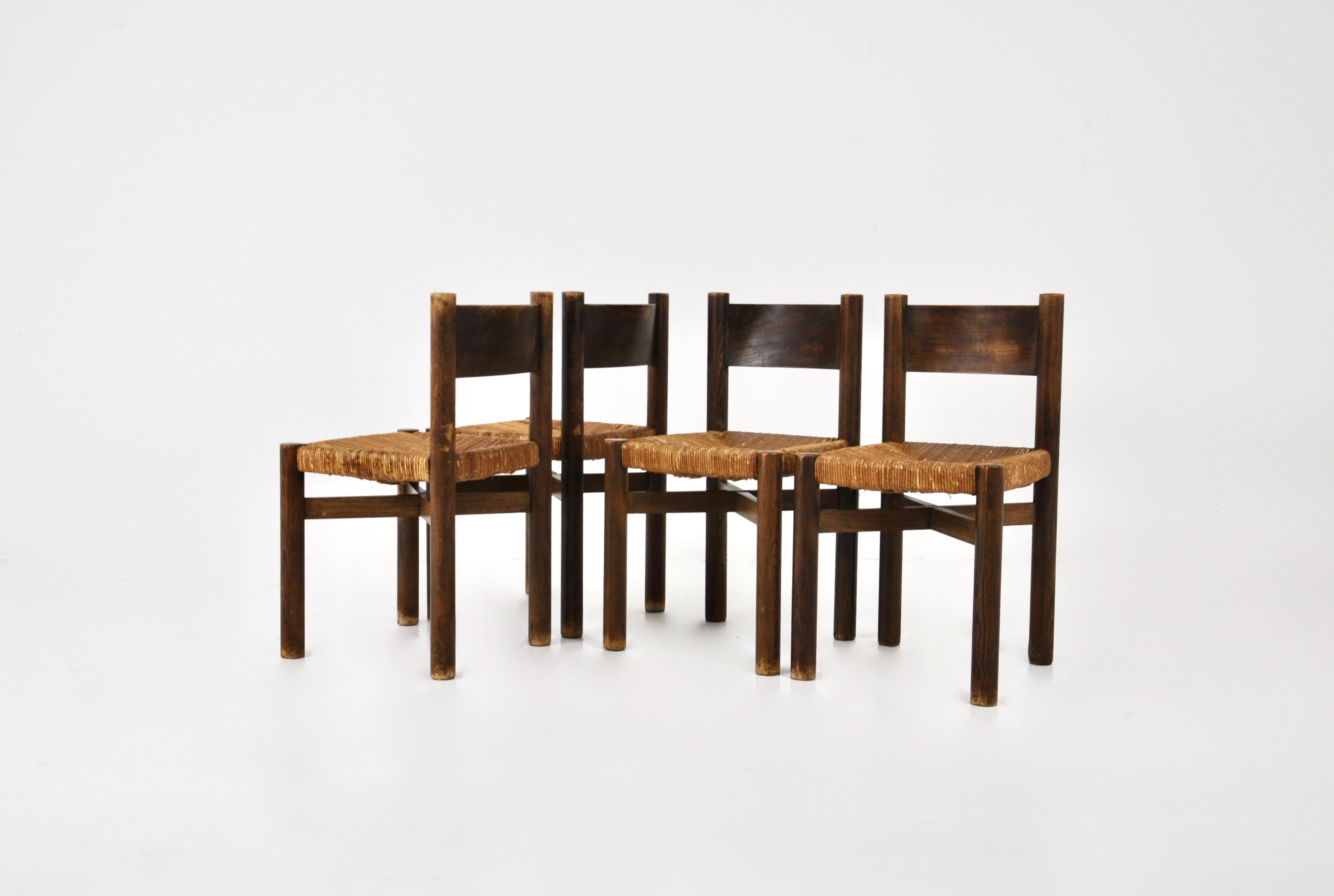 Satz von 4 Holzstühlen mit Strohsitz, entworfen von Charlotte Perriand in den 1950er Jahren, Modell: Meribel. Sitzhöhe: 45 cm. Abnutzung durch Zeit und Alter des Stuhls.