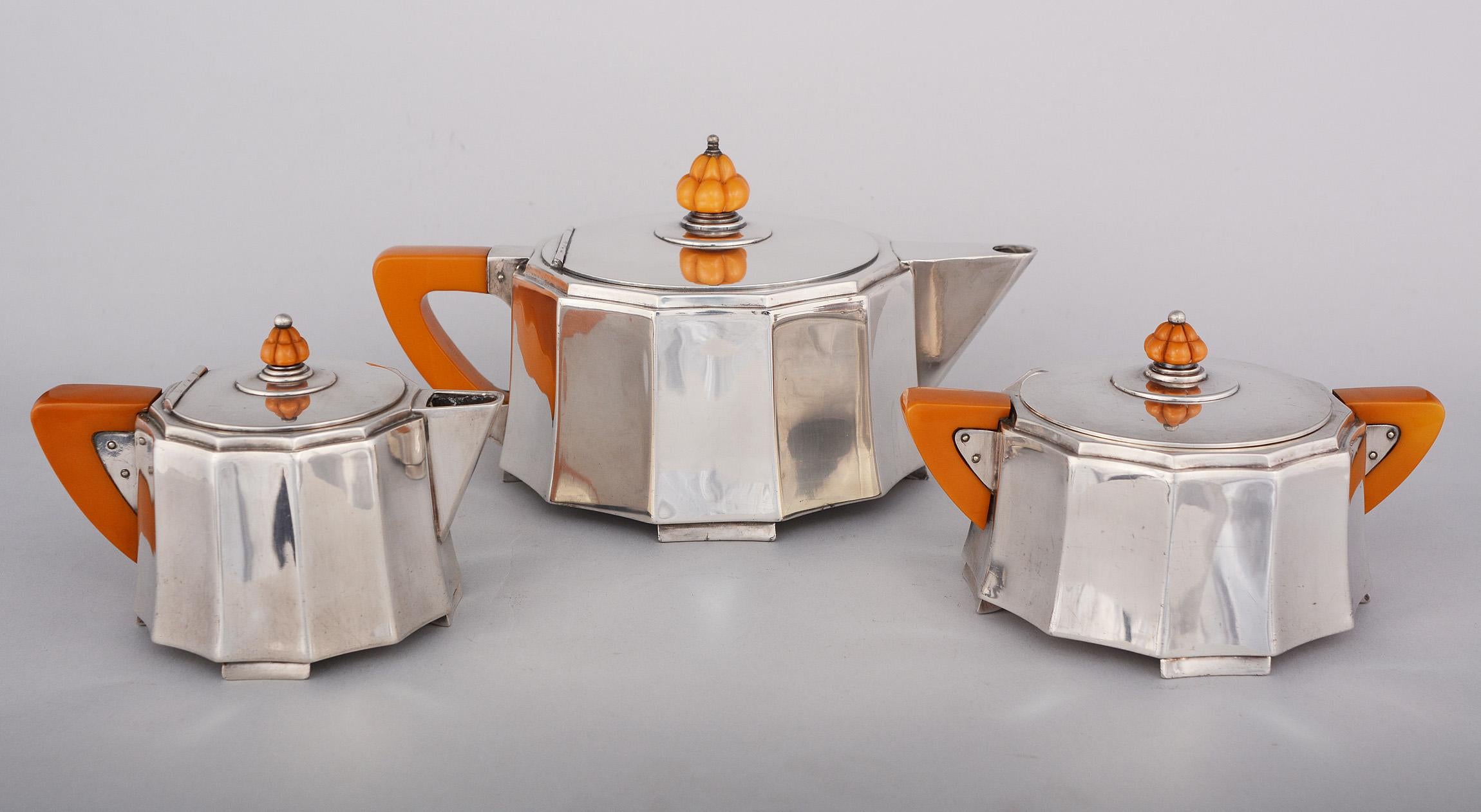Silver plate and bakelite Art Deco tea set by Meriden. This set has dramatic fluted sides with angular handles and spouts. The set consists of a teapot, creamer and sugar. The set shows normal wear with light scratches and marks.