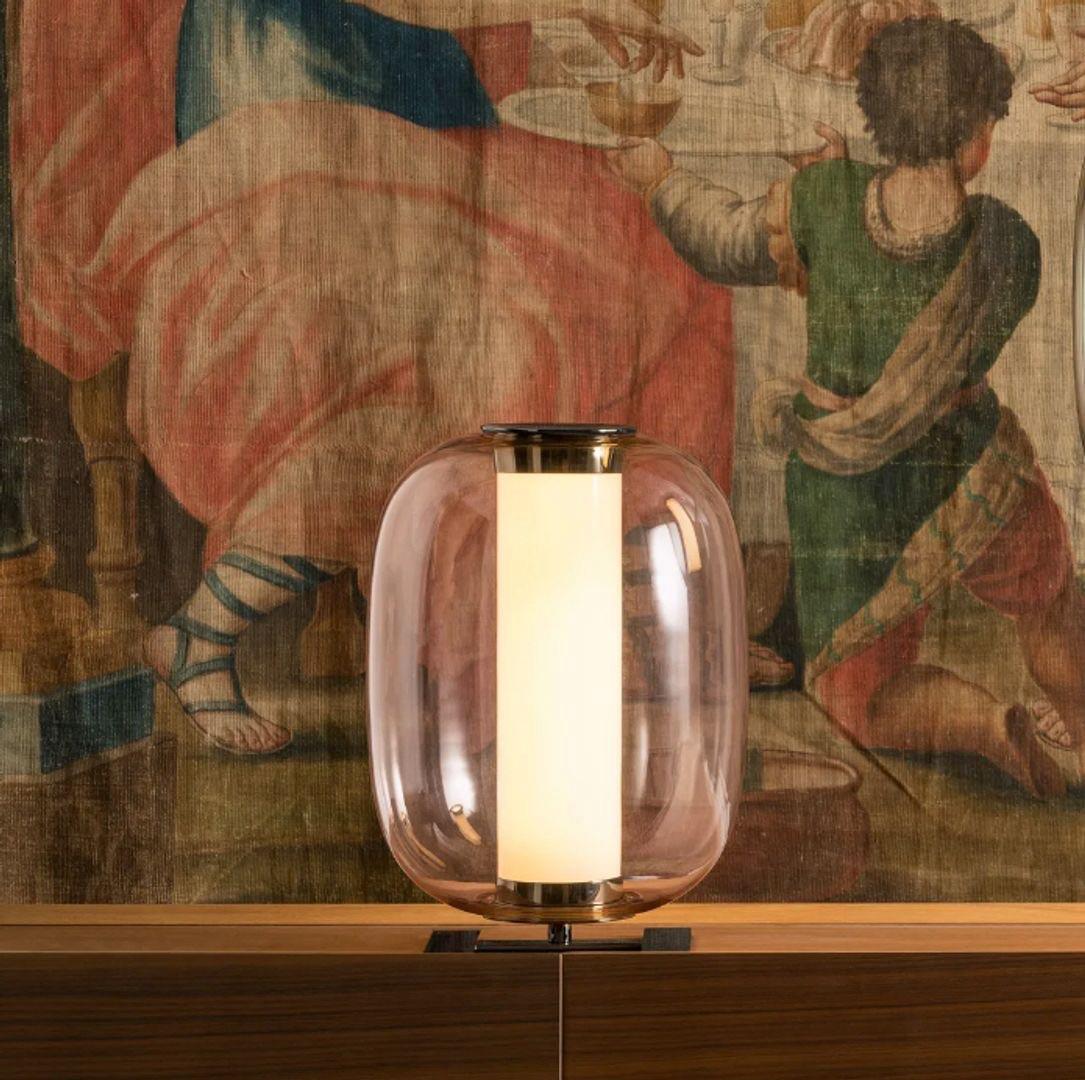 La lampe à poser Meridiano présente une forme géométrique unique avec un diffuseur arrondi en verre satiné. Elle diffuse doucement la lumière, créant une lueur douce et ambiante, parfaite pour les intérieurs contemporains. La base de la lampe est