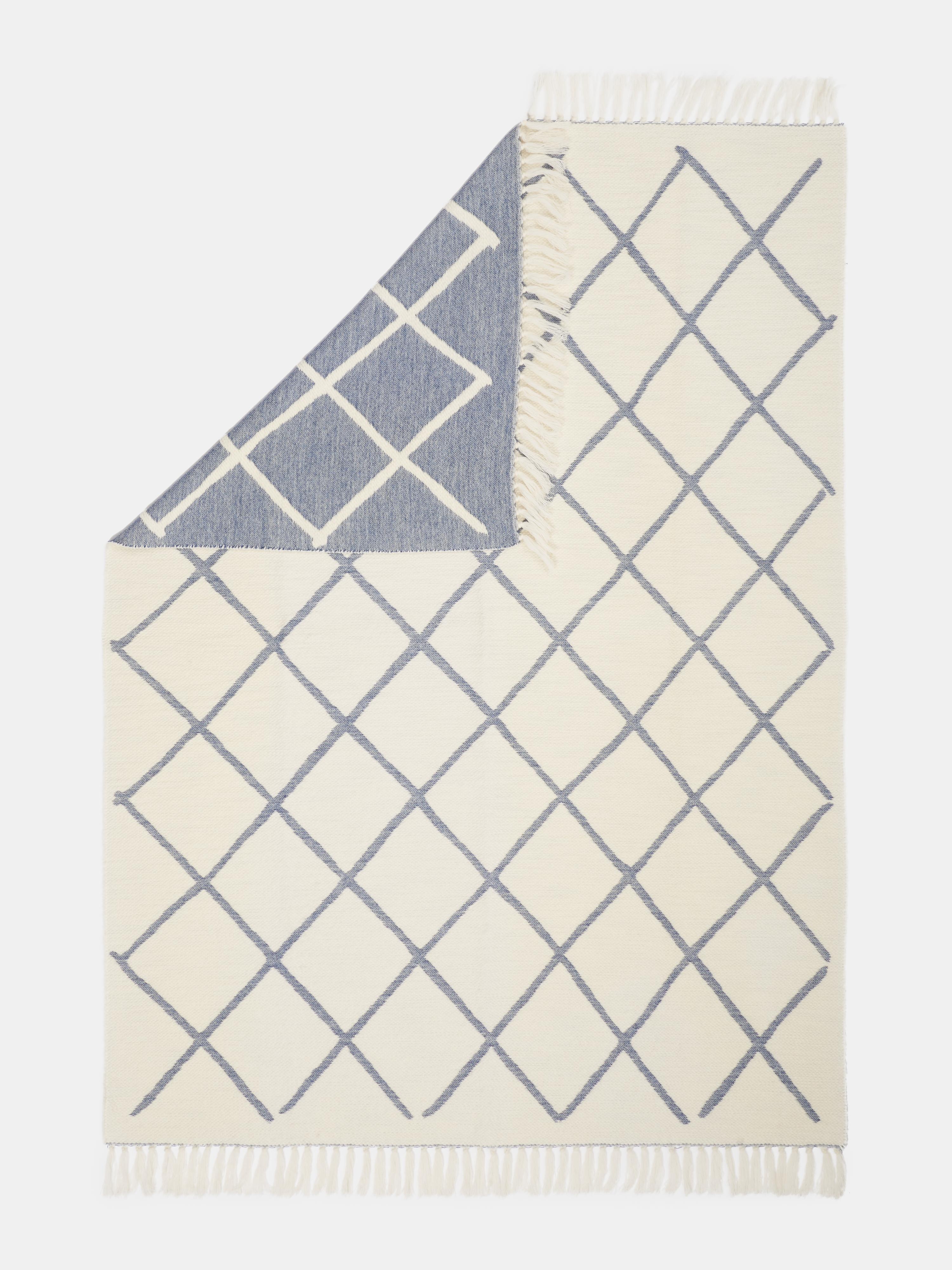 Realizzato a Como, in Italia, questo lussuoso giaciglio è realizzato al 100% in pregiata lana merino, che offre calore, morbidezza e traspirabilità naturali. Il motivo jacquard a rombi presenta un bellissimo design reversibile - un lato in avorio