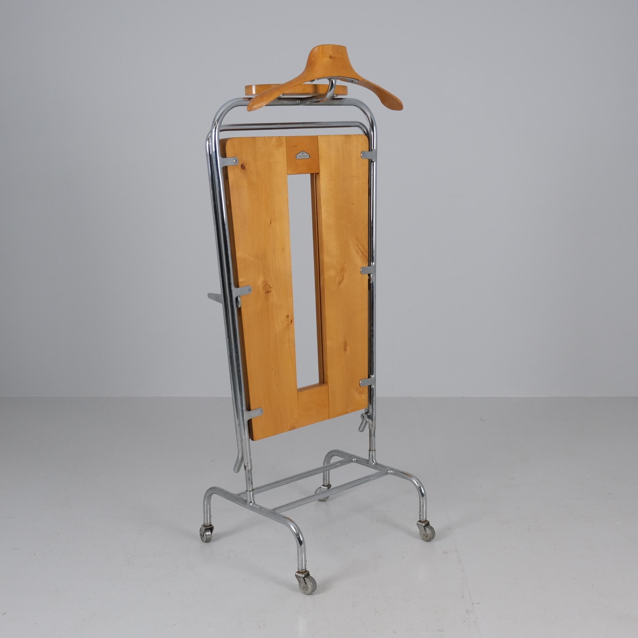 Un valet de chambre classique, extrêmement élégant et très fonctionnel, avec un presse-pantalon et un porte-clés, réalisé par l'estimé fabricant finlandais J.Merivaara, vers les années 1940. Cette pièce illustre le design industriel sophistiqué de