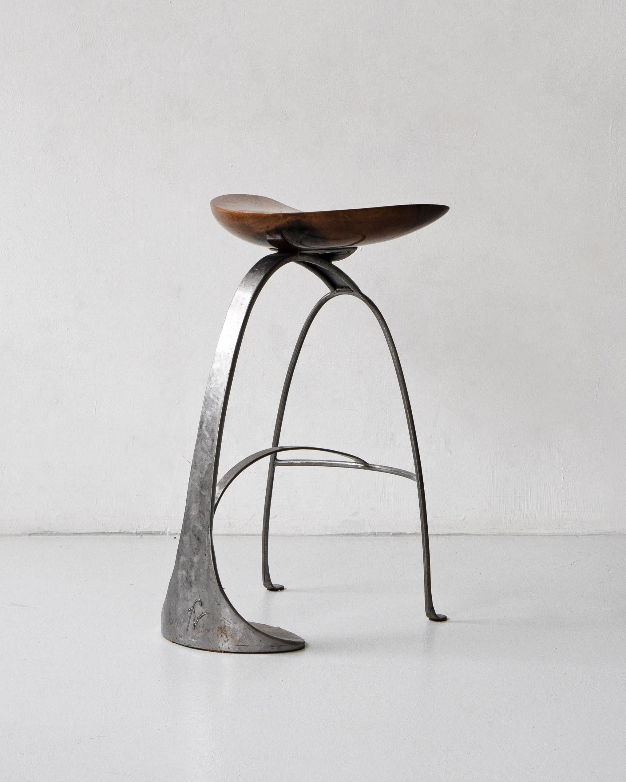 A very unusual bar stool made by French artist and maker Francis Veillerot (b. 1958).

Composed of a sculptural steel base and polished wooden seat. Monogrammed by the artist.

Francis Veillerot is an artisan craftsman that typically works with