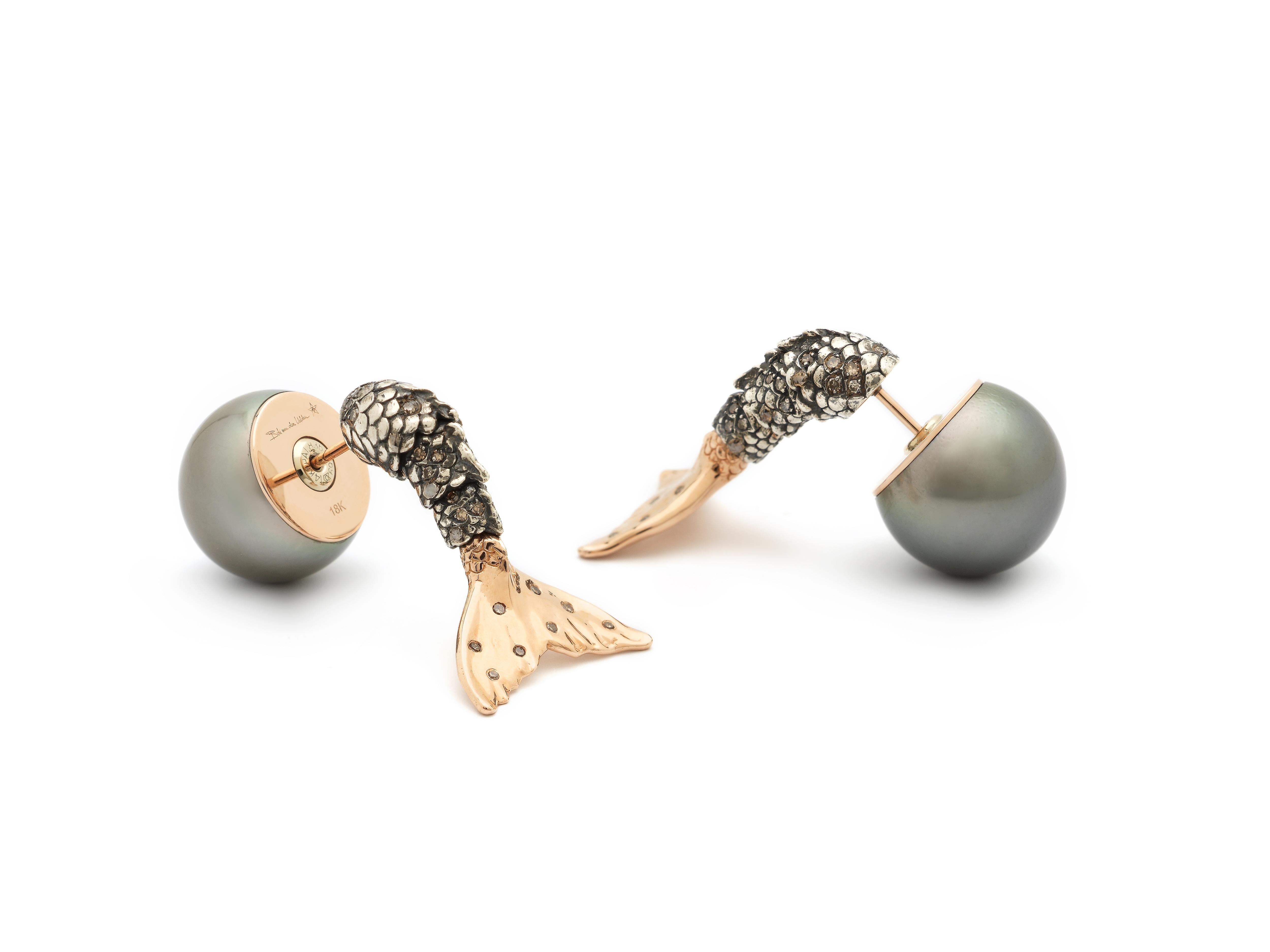These Mermaid Pearl Earrings spotlight a moving mermaid’s tail, complete with tactile, moving scales and a gold fin. Designed in 18k rose gold and sterling silver, the earrings are embellished with brown diamonds, and deep blue pearl backs.