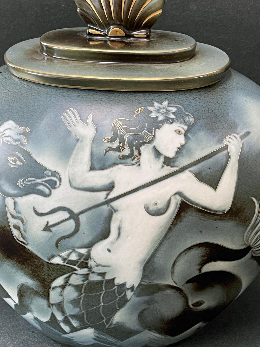 Large and exceptional, this lidded urn by Gunnar Nylund for the famed Rörstrand porcelain works in Sweden depicts two mermaids, one astride a hippocampus and the other riding a sea dragon, all in lovely shades of slate blue, charcoal and pale gray.