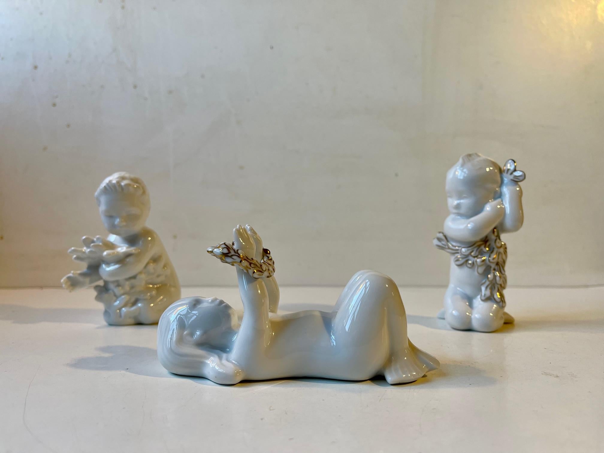 A group of the blanc de chine porcelain figurines two of which are special editions decorated with gold glaze. They are called oceans kids and they are perceived to be a mermaids offspring. Designed by Ebbe Sadolin and Svend Jespersen and