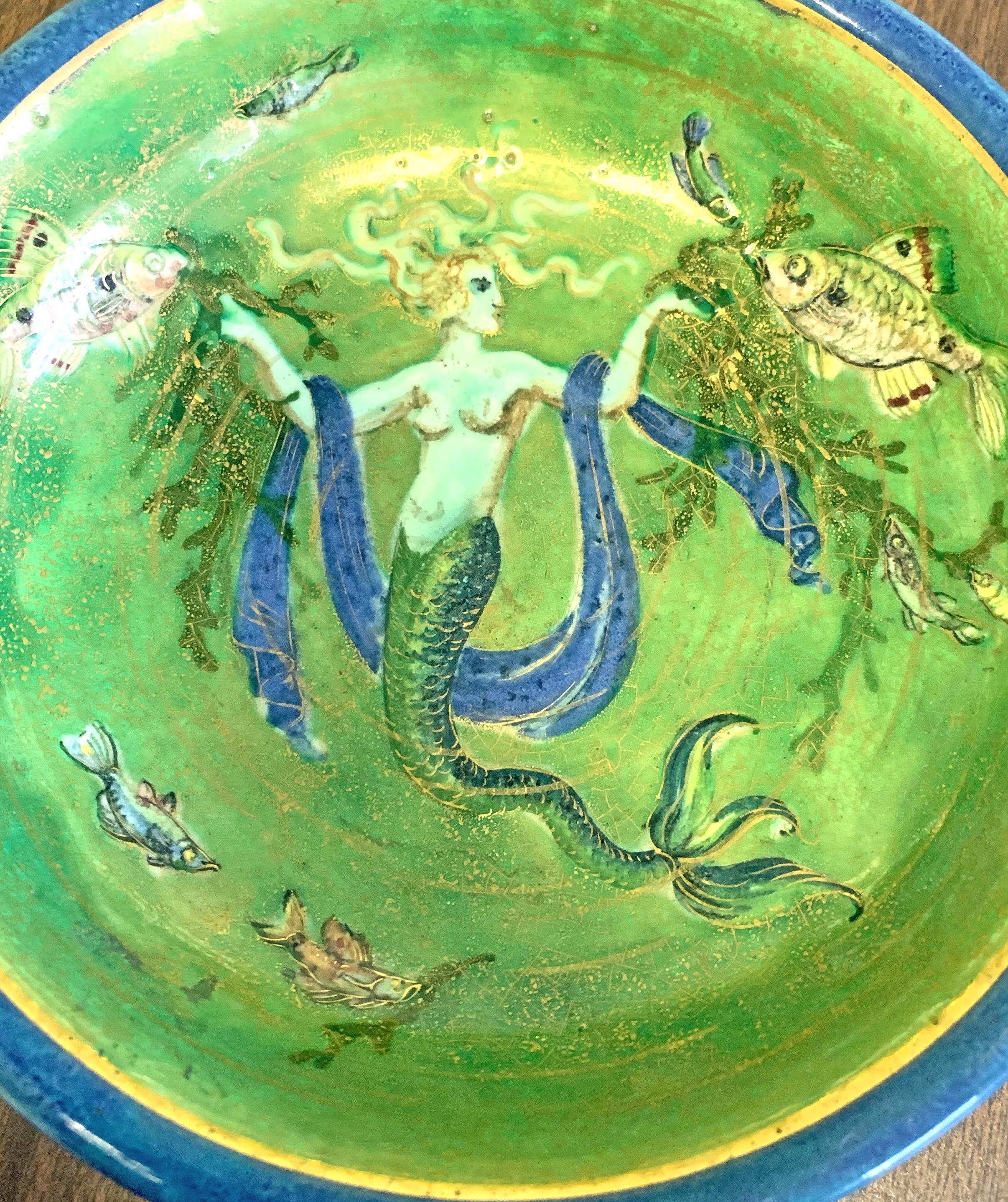 Glazed in gorgeous jewel tones, emerald green and sapphire blue, this unique and extraordinary Art Deco bowl was created by an artistic husband-and-wife team in France: Auguste and Odette Chatrousse Heiligenstein. Auguste was sometimes known for the