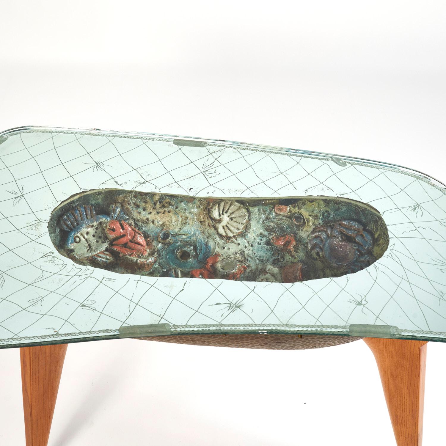 Unusual and decorative low table that imitates an aquarium. Made from a carved and hammered wood shell which contains a ceramic seabed, lightning system and it is covered by a partially mirrored glass. The structure is made from oakwood and it