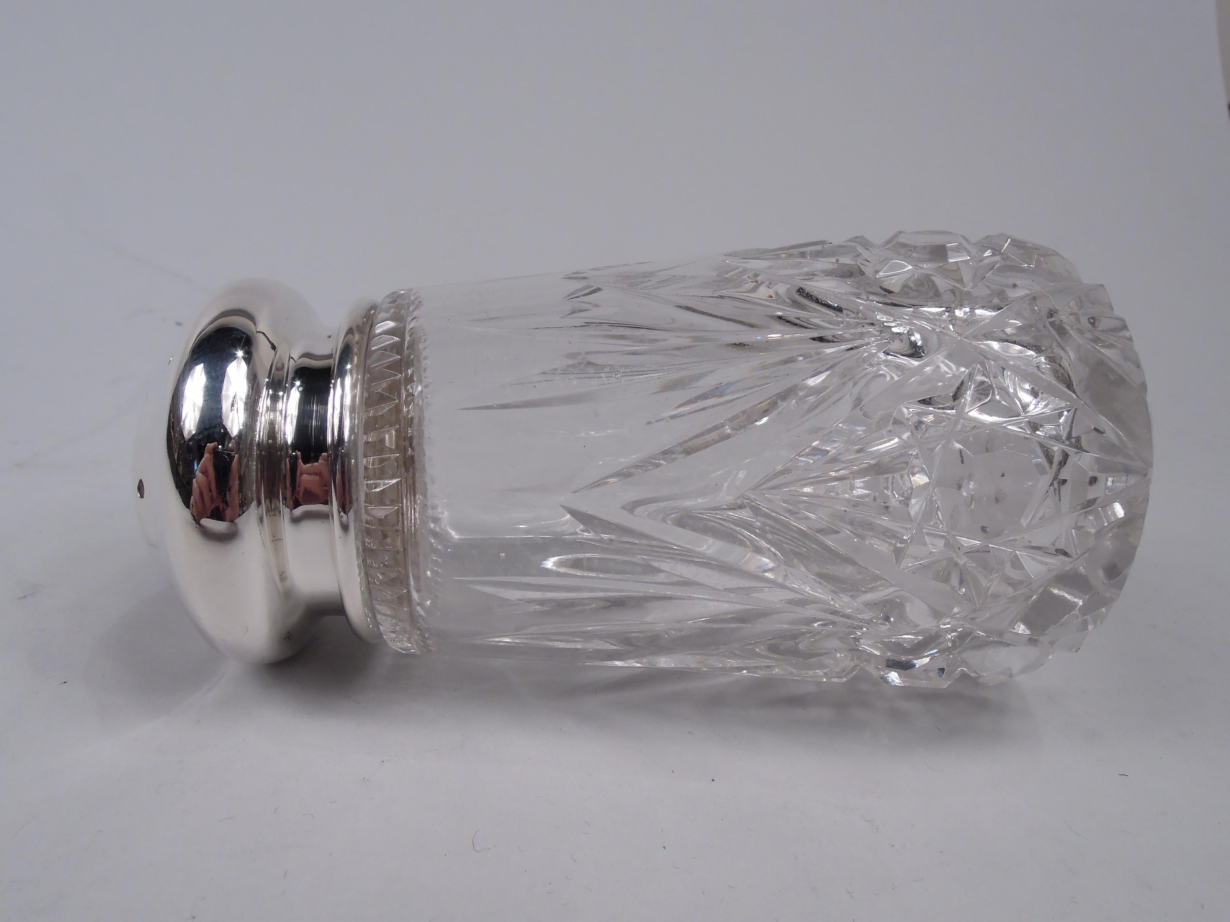Edwardian glass sugar caster with sterling silver cover. Made by the Merrill Shops in New York, ca 1910. Bowl has upward tapering sides with cut ferns and stars, and leaf mouth rim. Cover domed and pierced. Fully marked including maker’s stamp and