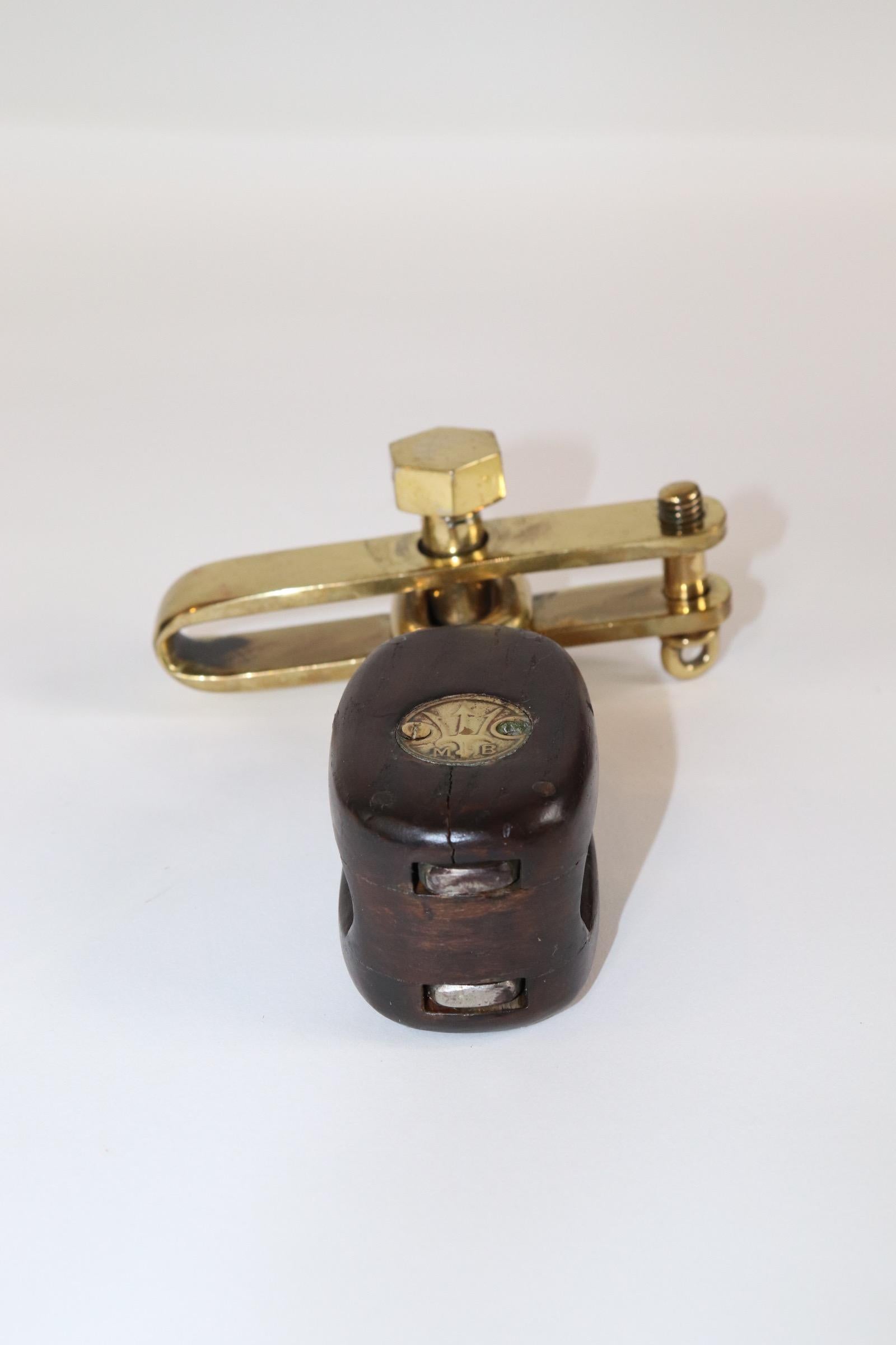 Old Merriman Brothers wood pulley block from a yacht. With brass caps with the Merriman Trident logo. Other polished brass hardware is attached. Weight is 2 pounds. X-135