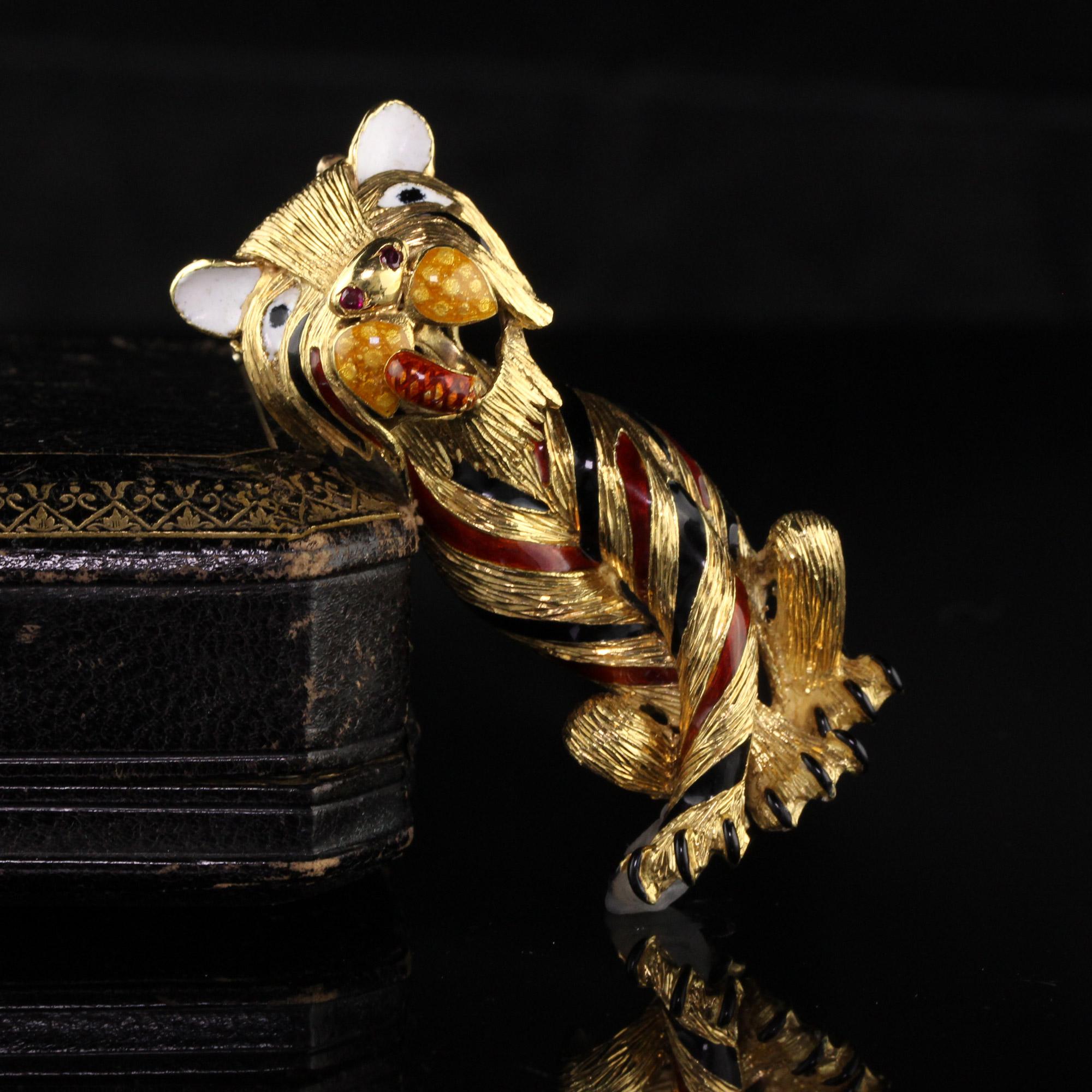 Beautiful retro tiger pin and pendant with 2 rubies as the tiger's nostrils. The enamel is in great condition.

Item #P0091

Metal: 18K Yellow Gold

Weight: 35.5 Grams

Measurements: 2.3 in x 0.9 in 