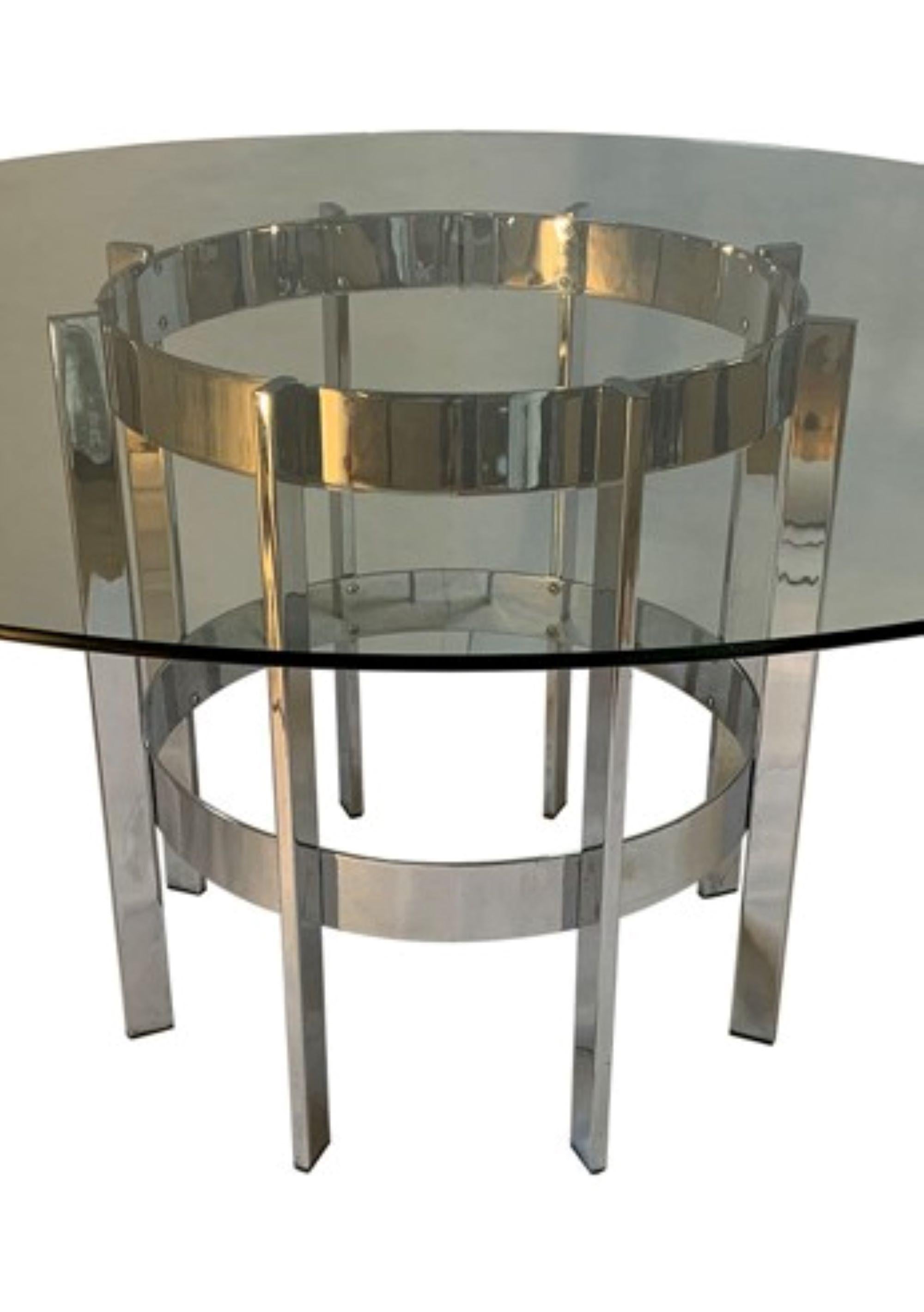 Associates dining table, named 'The Preece'. 

Large Circular clear toughened glass top dining with chrome base, designed by Richard Young in the late 1970s. 
Merrow Associates was started by Richard Young, who is a former Royal College of Art