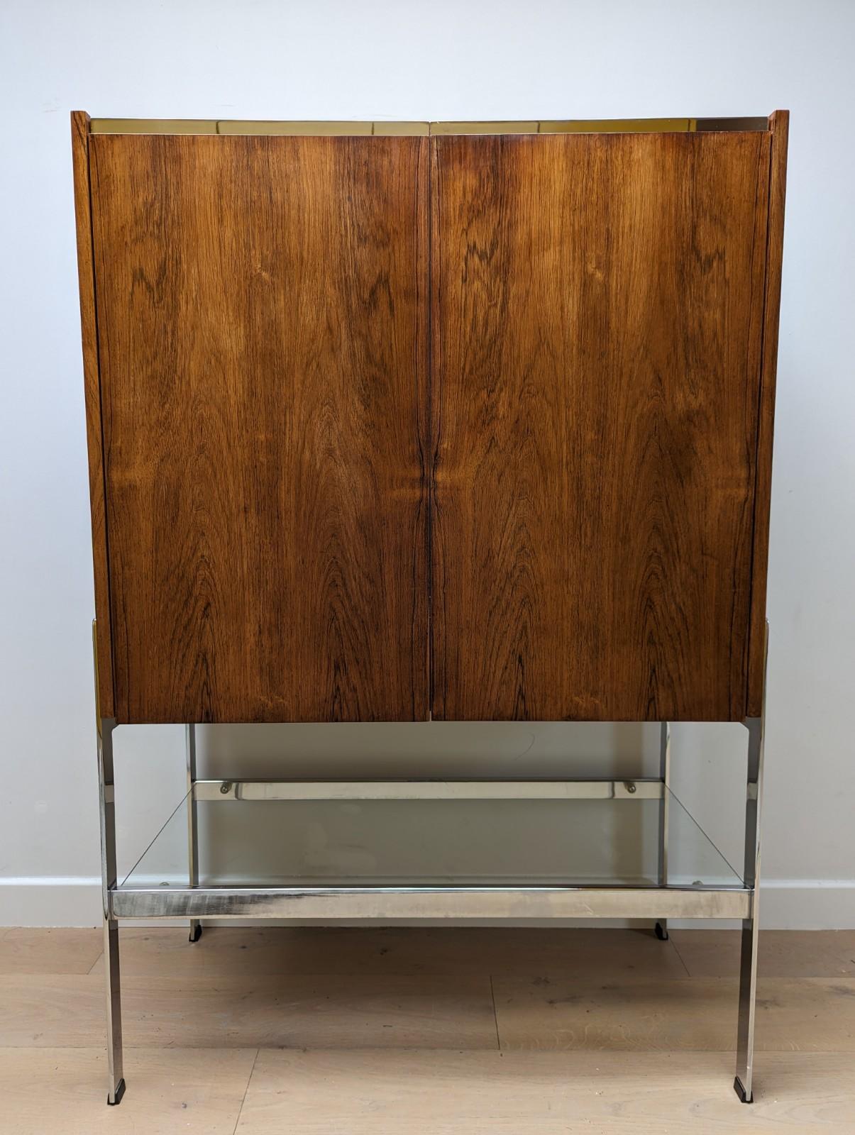 A very rare and stunning mid-century cocktail cabinet by Merrow Associates known as 'The Drummond 406R'.

The item has undergone some light restoration to ensure it is presented in very good vintage condition.

Made from Santos rosewood with