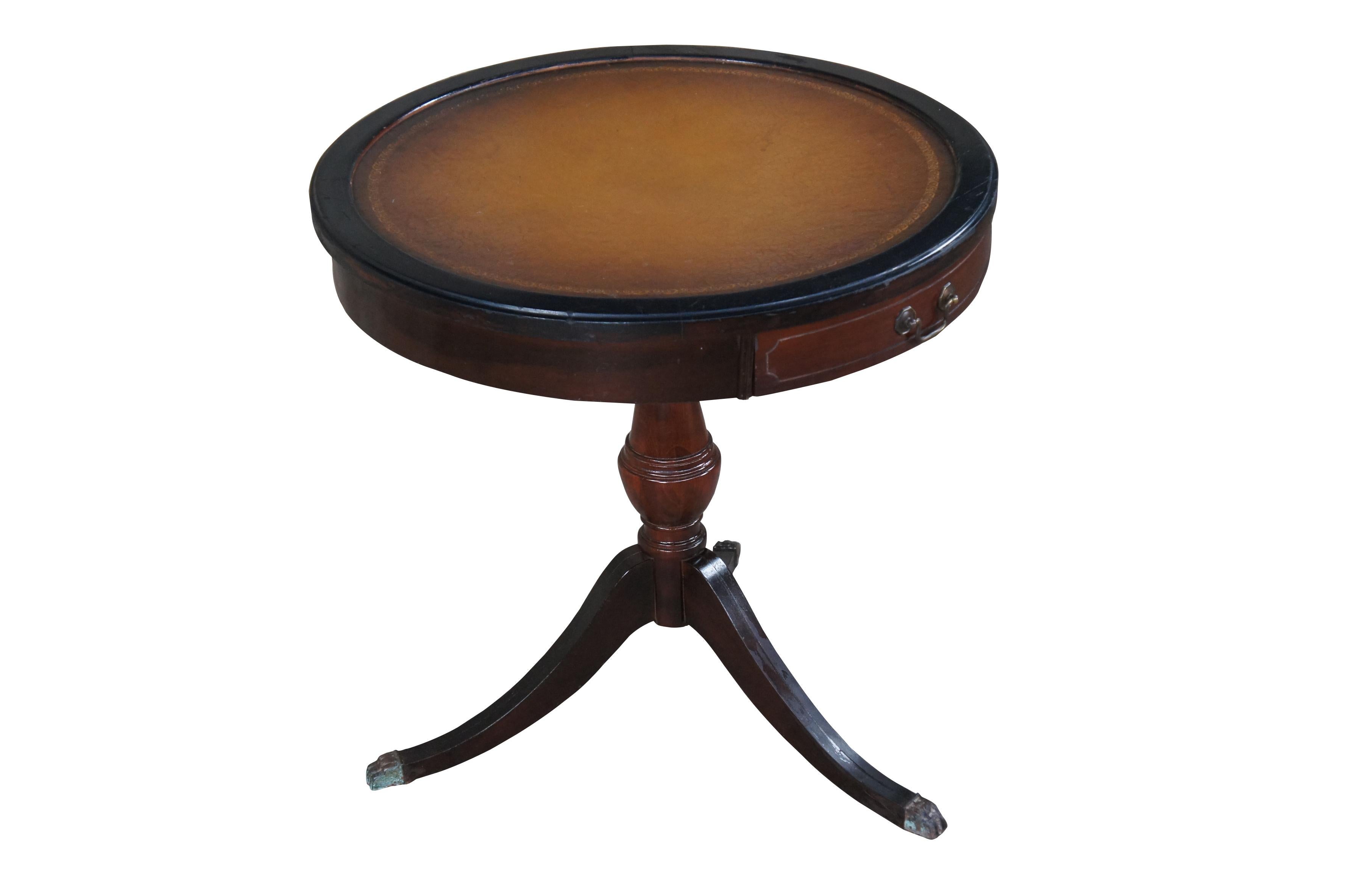 Mid 20th century Mersman side table.  Made of mahogany featuring round form with tooled leather top, one drawer, and tri foot pedestal base with brass capped claw feet.

The company was founded as ‘Mersmans Tables’ in the 1870s by sawmill owner J.