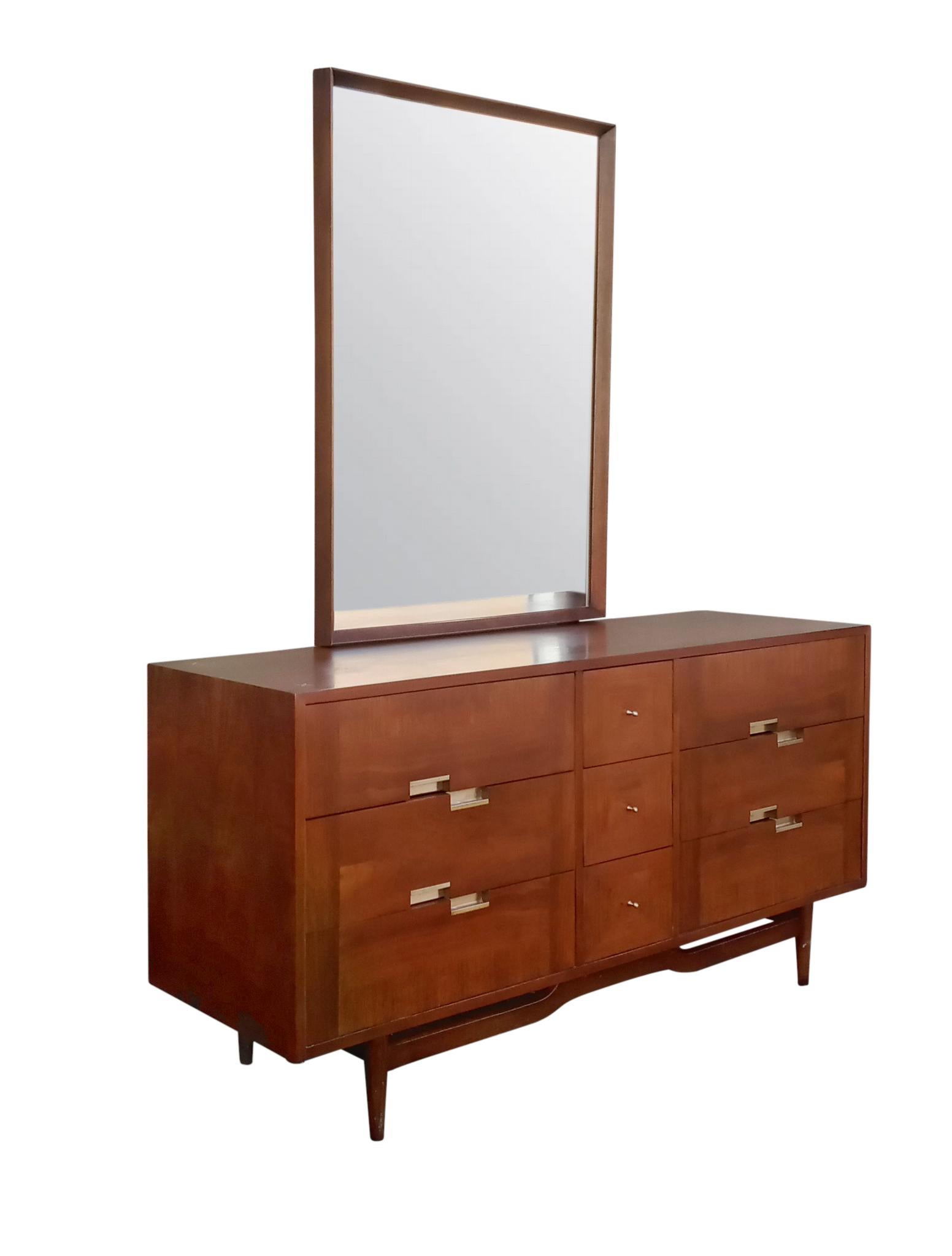 Offering a nice Mid-Century Modern dresser or credenza with mirror by Merton Gershun for American of Martinsville. The dresser offers three drawers on each side with aluminum offset pulls. The center offers three drawers for a total of nine drawers