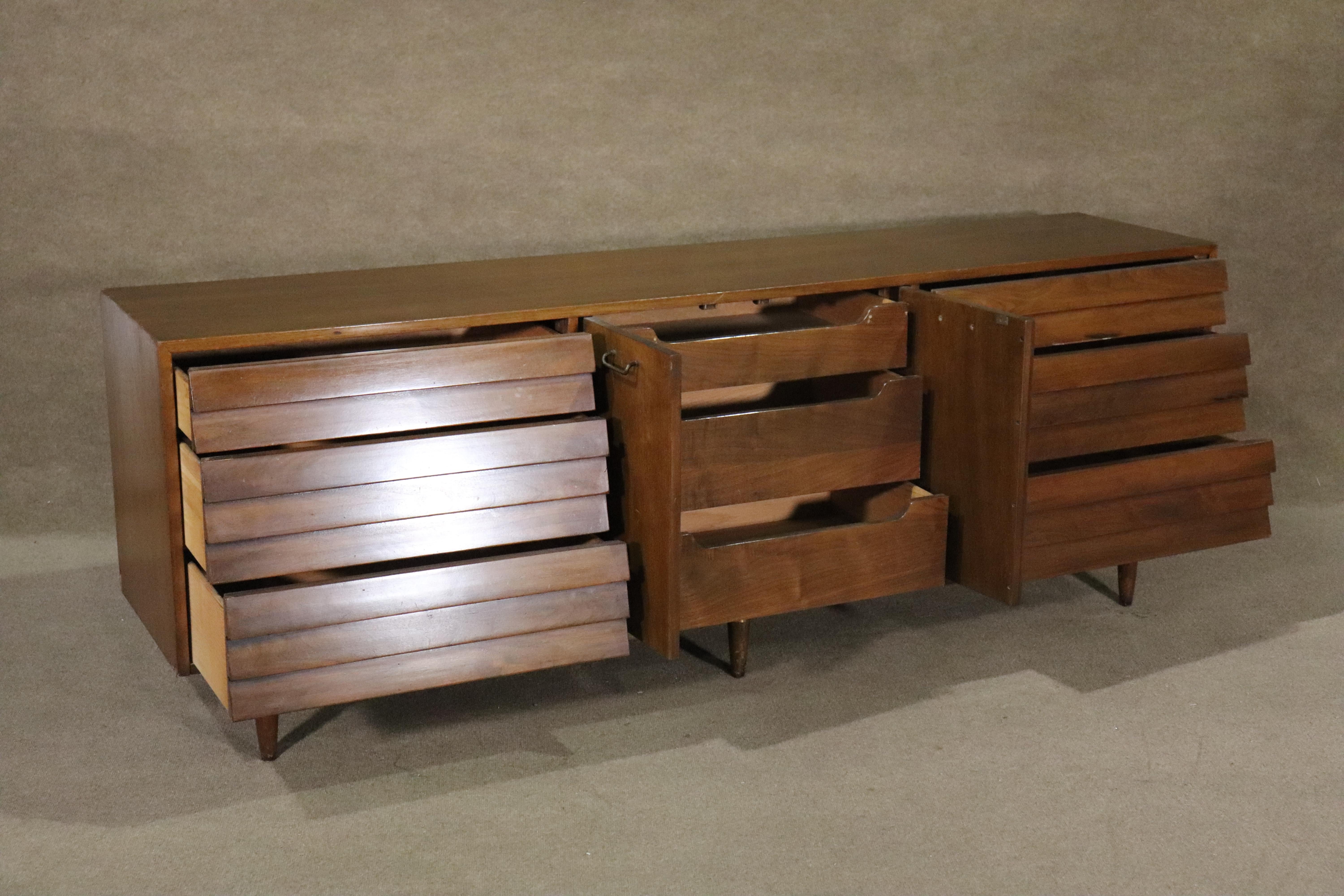 Stunning mid-century design by Merton Gershun for Martinsville. Long walnut dresser with louvered front drawers, brass trim, and hidden drawers in the middle.
Please confirm location NY or NJ