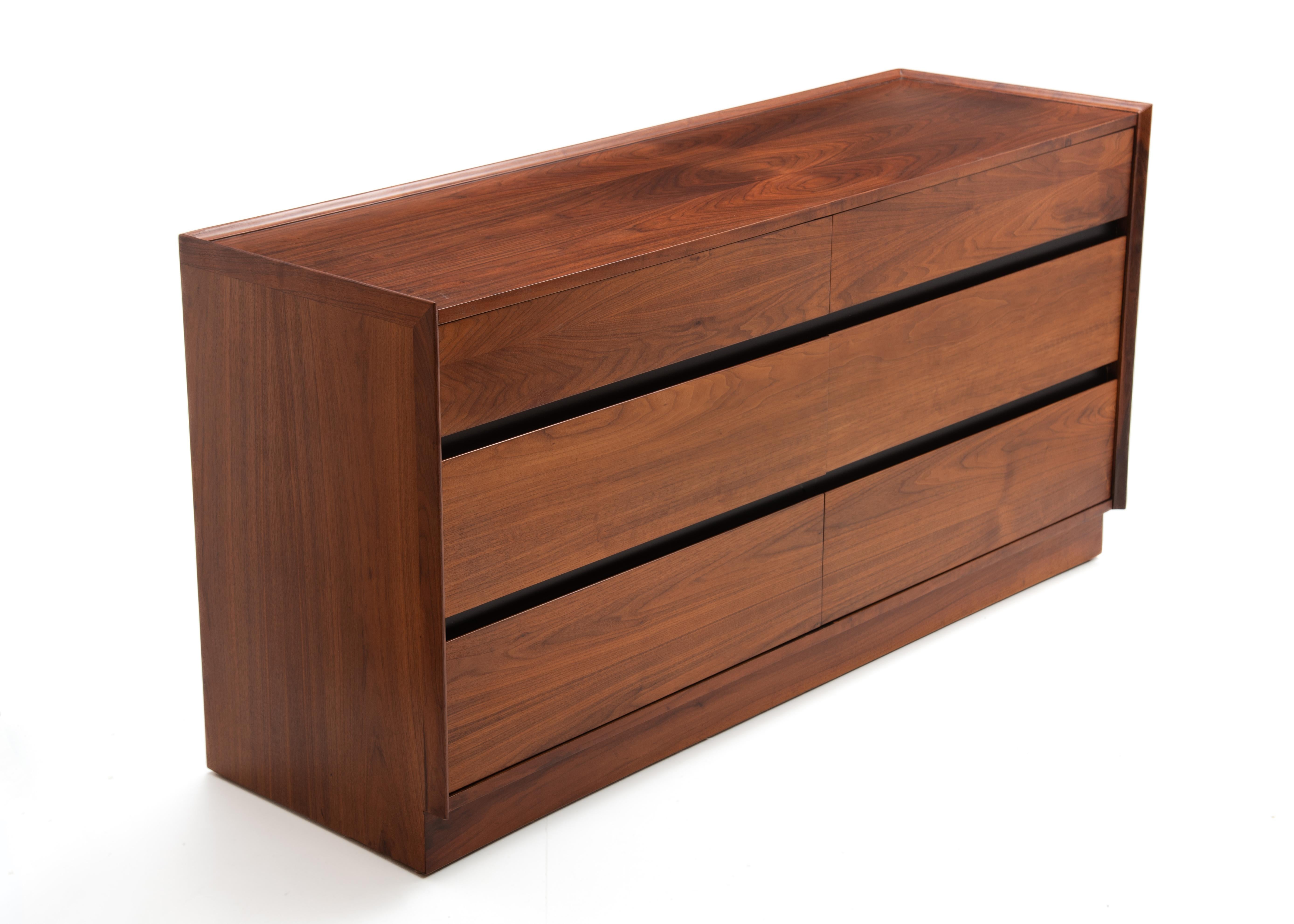 Esta impresionante cómoda Dillingham Esprit fue diseñada por Merton Gershun para American of Martinsville. La cómoda tiene seis cajones espaciosos con un elegante diseño de ranuras inferiores para facilitar su manejo. Fabricada en cálido nogal a