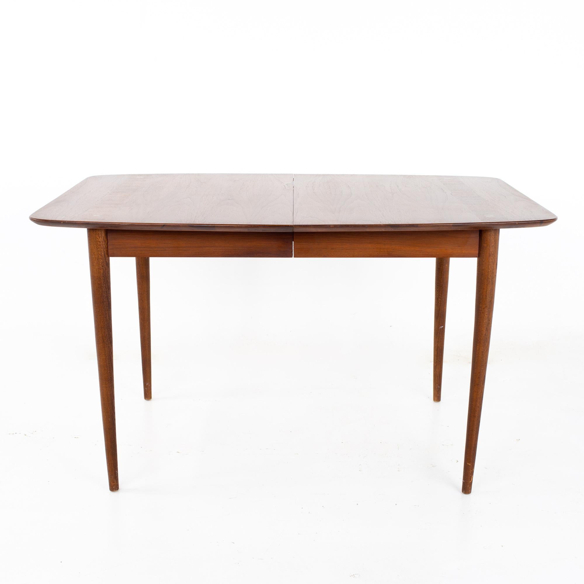 Merton Gershun for American of Martinsville Dania mid-century dining table.

Table measures: 60 wide x 39 deep x 30 inches high, with a chair clearance o 28 inches, each of the 2 leaves are 12 inches wide, making a maximum table width of 84 inches