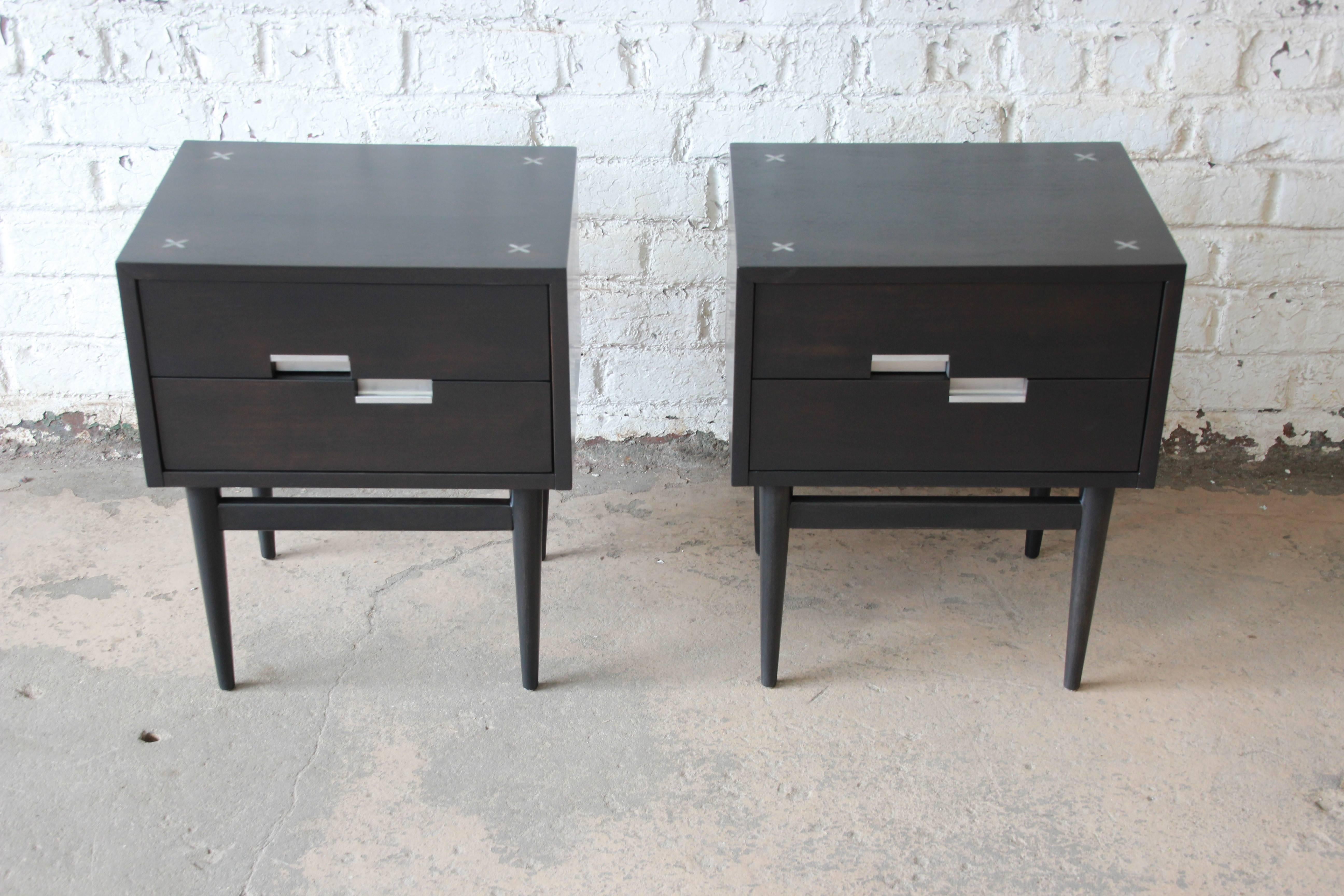 An exceptional pair of Mid-Century Modern ebonized nightstands designed by Merton Gershun for American of Martinsville, circa 1960s. The nightstands feature Gershun's iconic aluminum drawer pulls and 