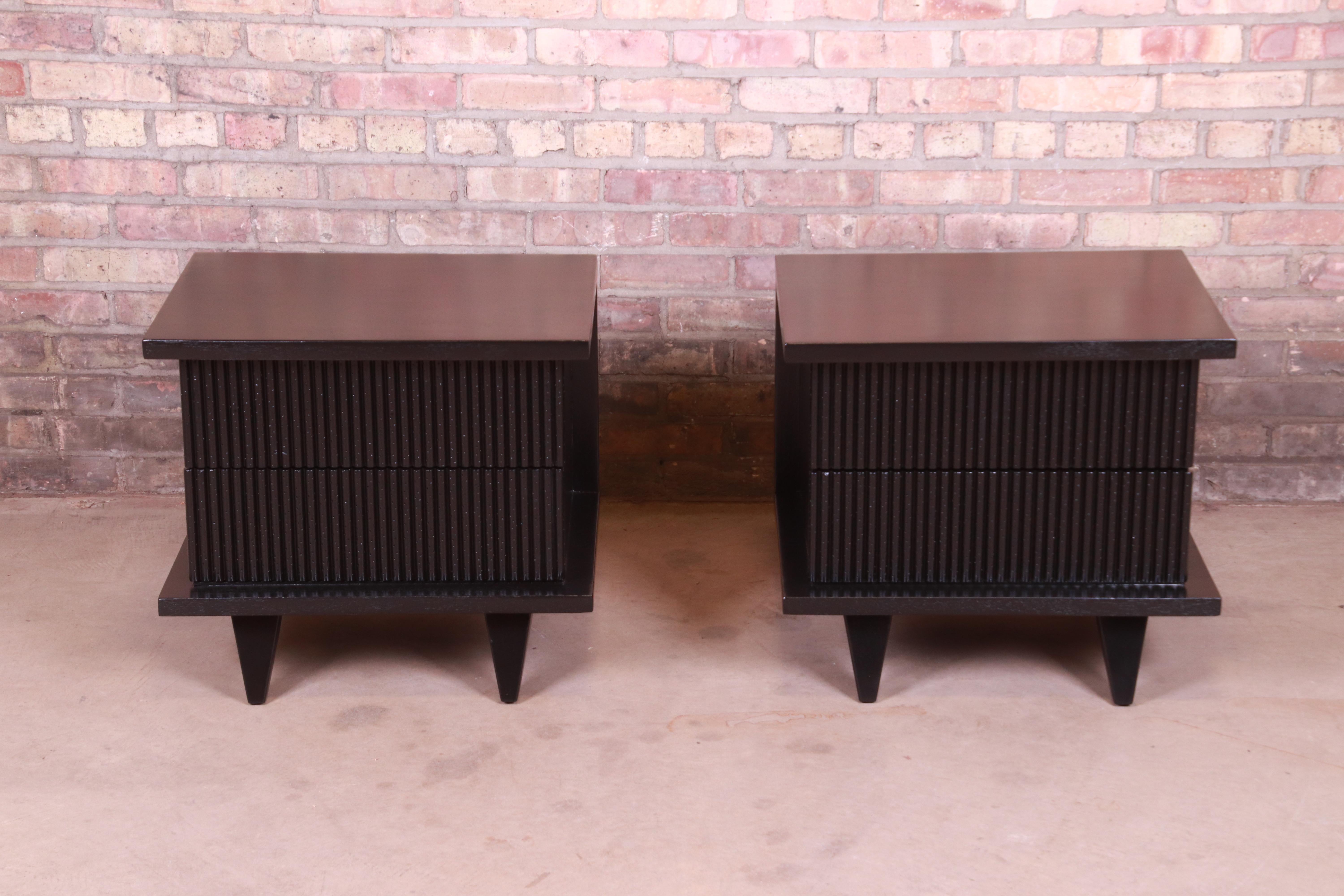 An exceptional pair of Mid-Century Modern black lacquered nightstands

By Merton Gershun for American of Martinsville

USA, 1950s

Black lacquered mahogany, with unique fluted drawer fronts with wormhole accents to add texture. Evident