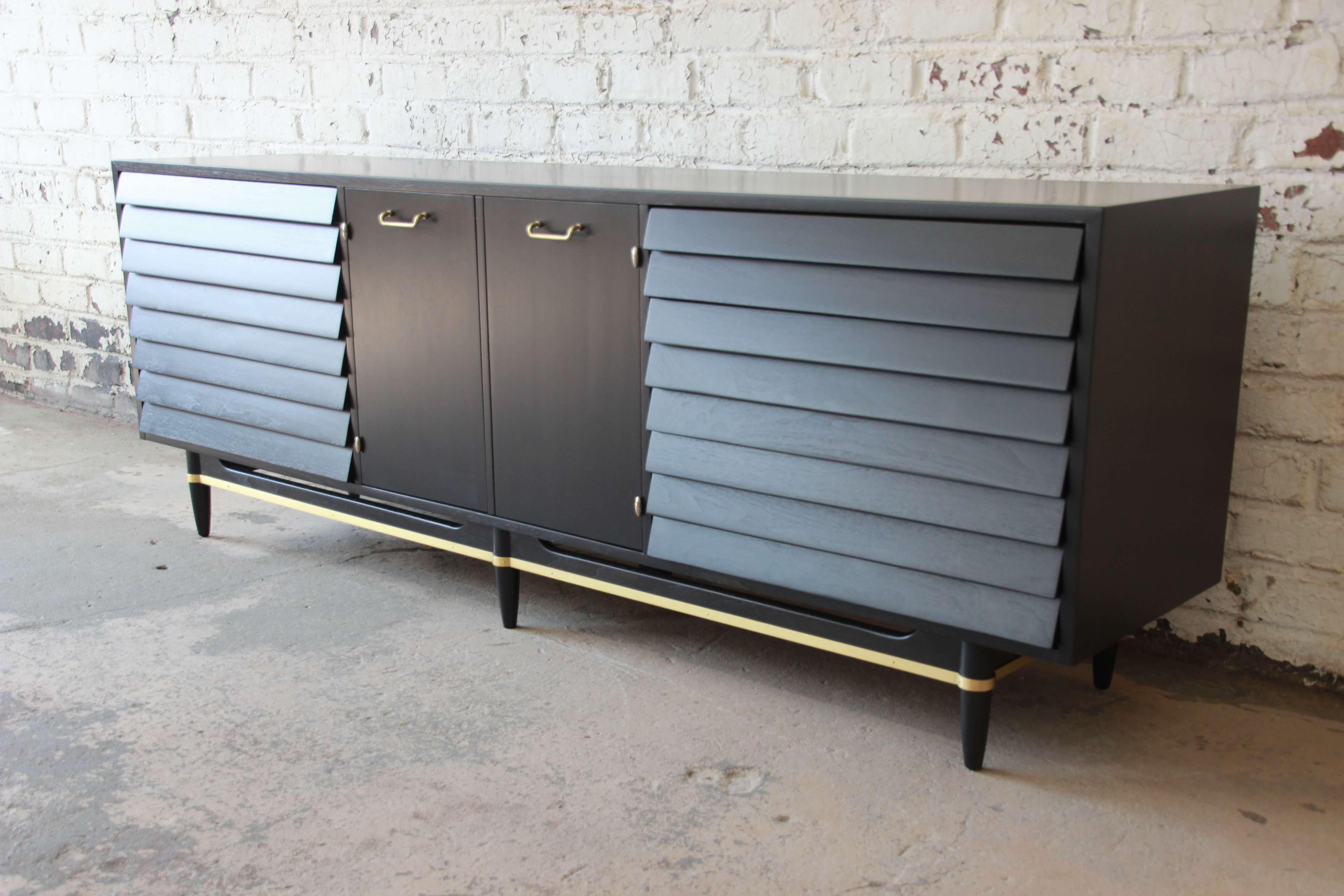 Offering an outstanding unique piece to the market, Merton Gershun louvered door ebonized dresser or credenza. This piece has been pristinely refinished in a ebonized walnut. Each end of the cabinet offers three large louvered drawers. The two