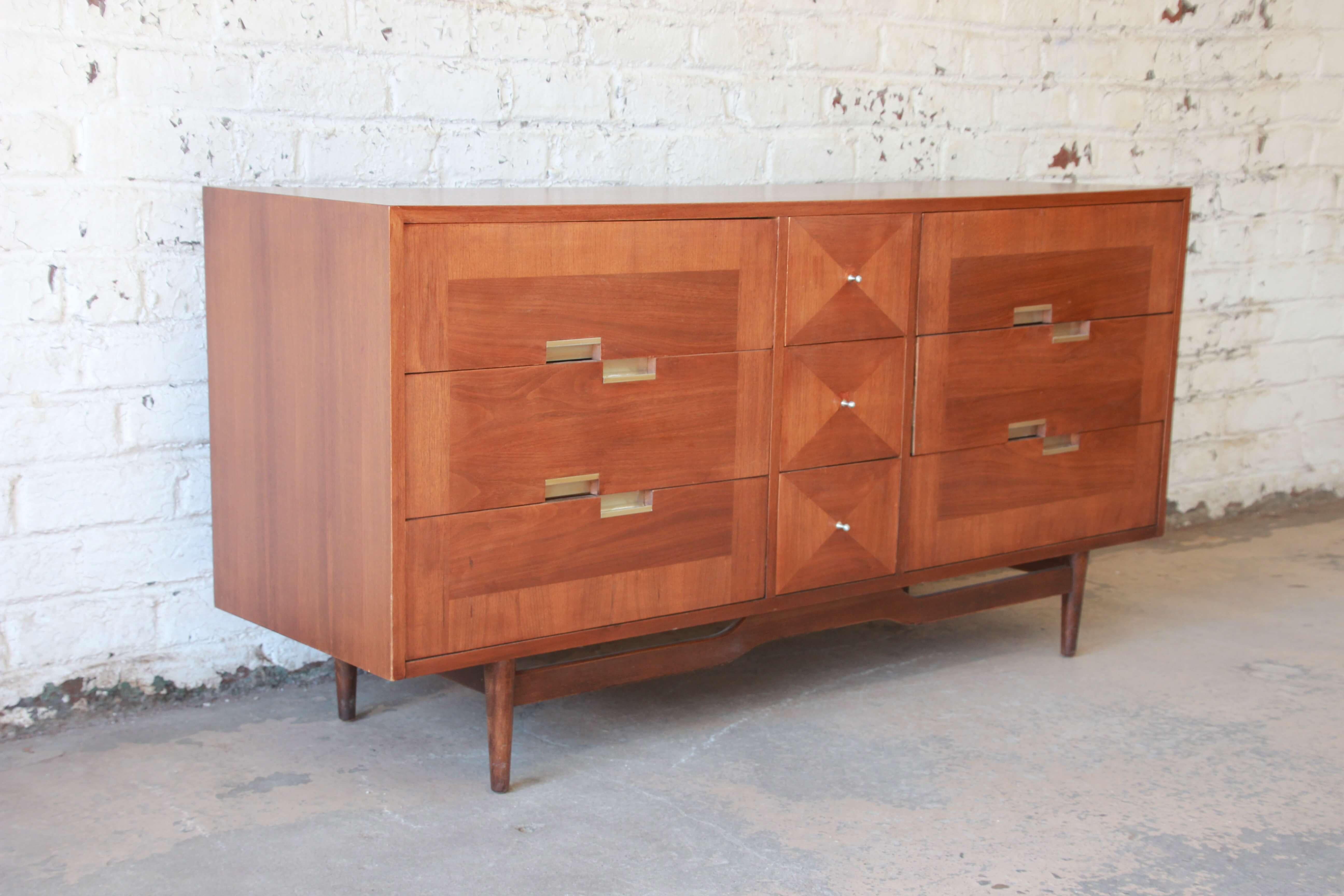 Offering a nice Mid-Century Modern dresser or credenza by Merton Gershun for American of Martinsville. The dresser offers three drawers on each side with aluminum offset pulls. The centre offers three centre drawers for a total of nine drawers for