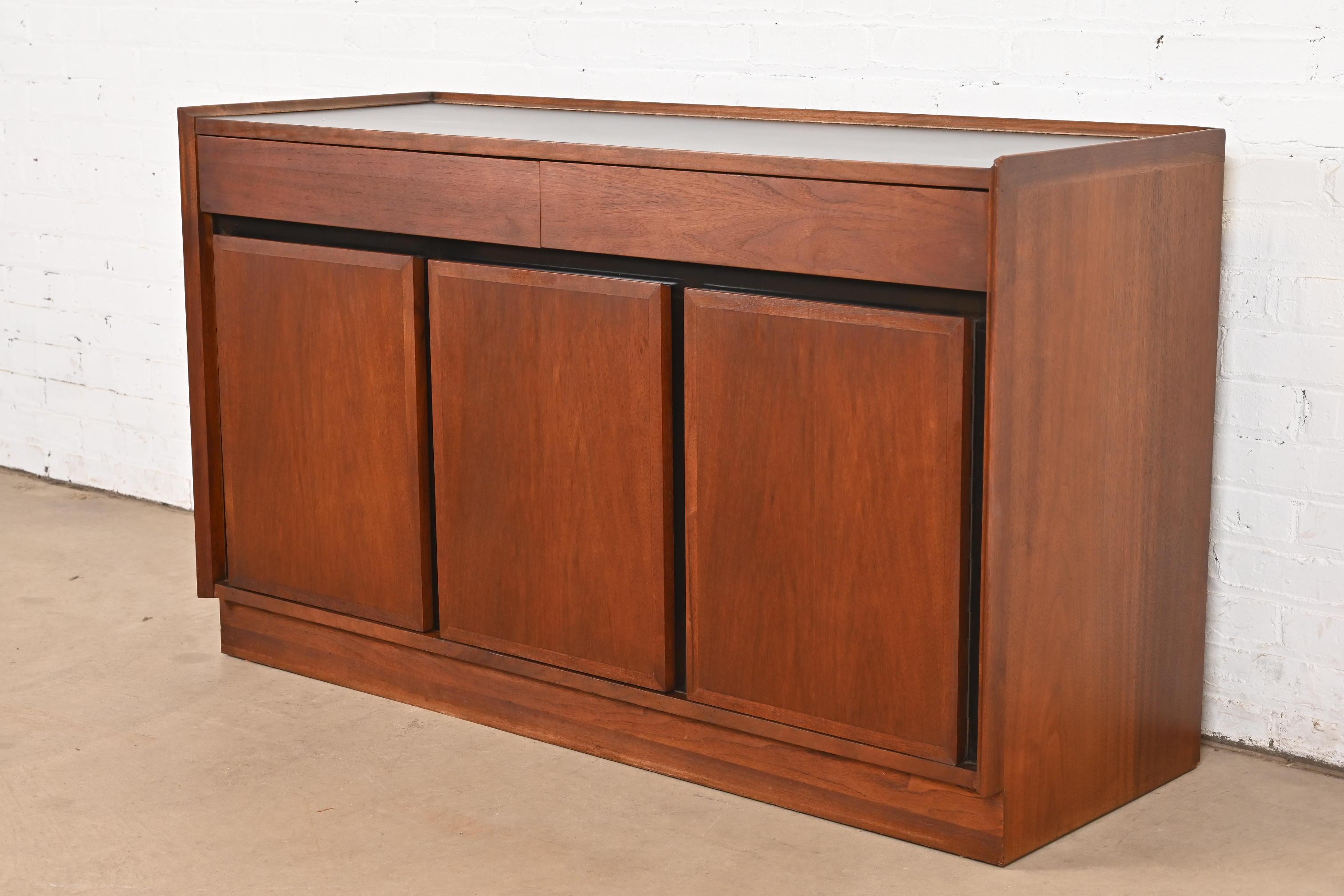 A sleek Mid-Century Modern sideboard, credenza, or bar cabinet

By Merton Gershun for Dillingham

USA, Circa 1960s

Gorgeous walnut, with durable black laminate top and trim.

Measures: 52.13
