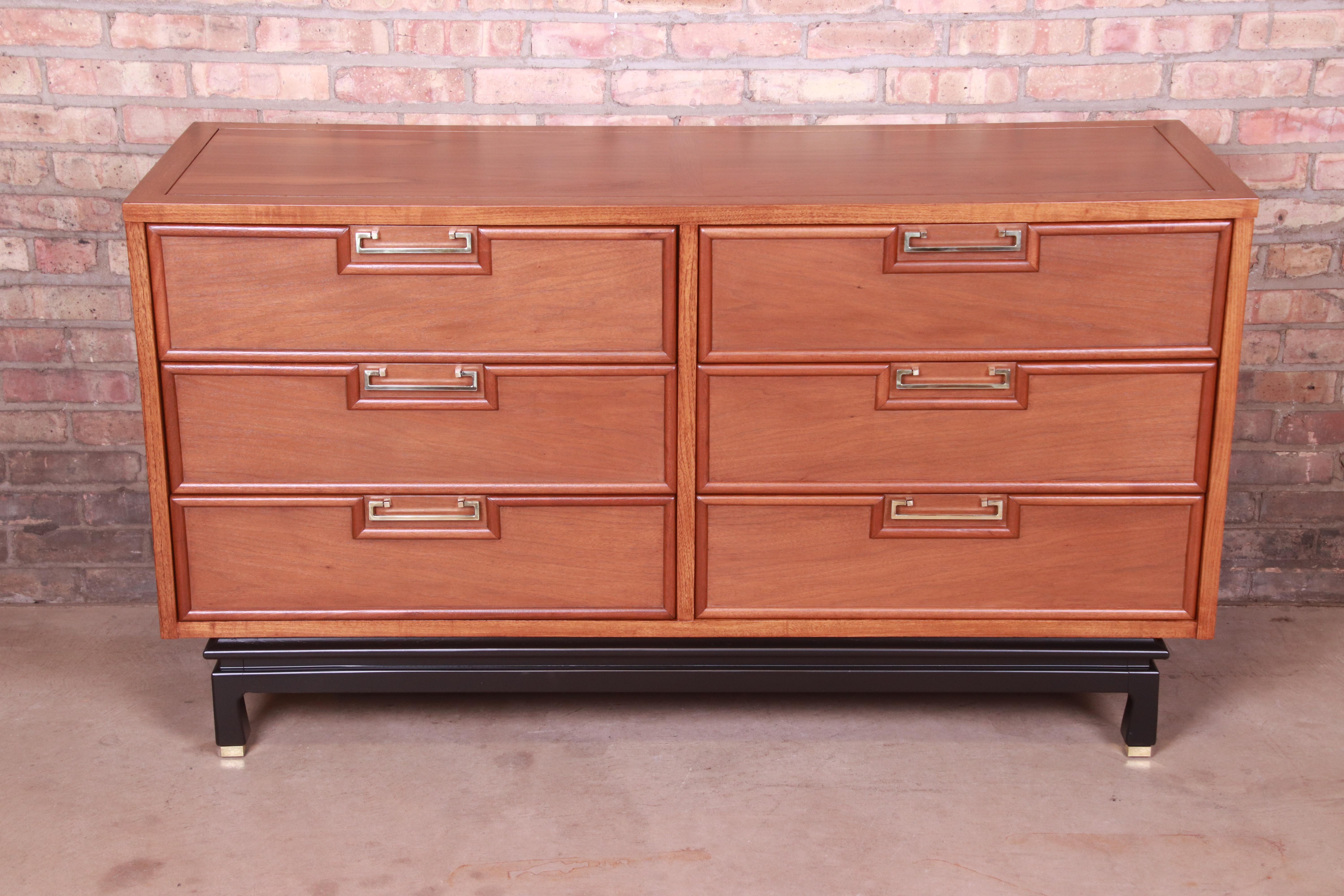 An exceptional Mid-Century Modern Hollywood Regency Chinoiserie dresser or credenza

By Merton Gershun for American of Martinsville

USA, 1960s

Walnut, with black lacquered legs, original Asian-inspired brass hardware, and brass-capped