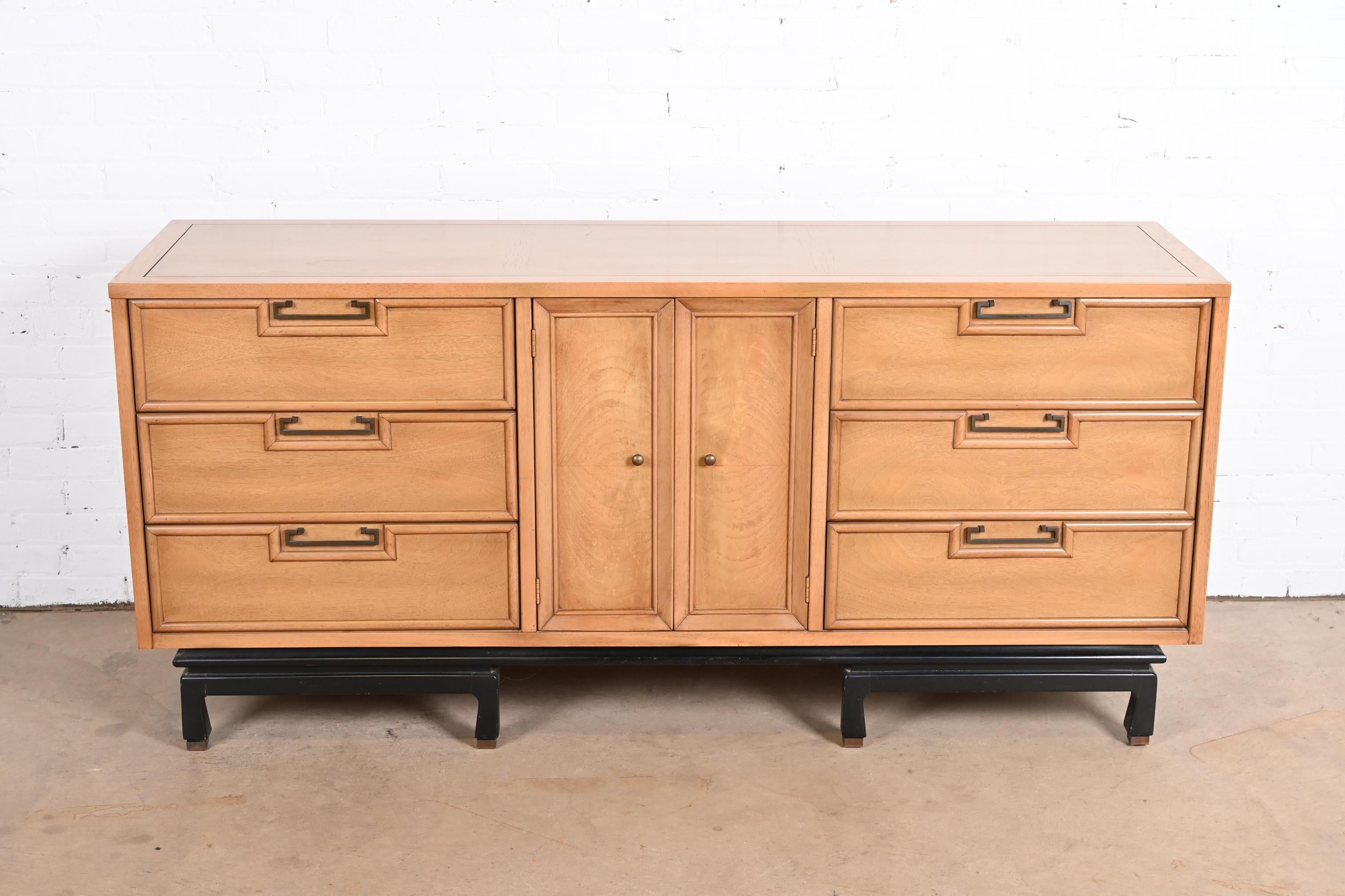 A gorgeous mid-century modern Hollywood Regency Chinoiserie triple dresser or credenza

By Merton Gershun for American of Martinsville

USA, 1960s

Bleached walnut and burl woods, with ebonized base, original Asian-inspired brass hardware, and
