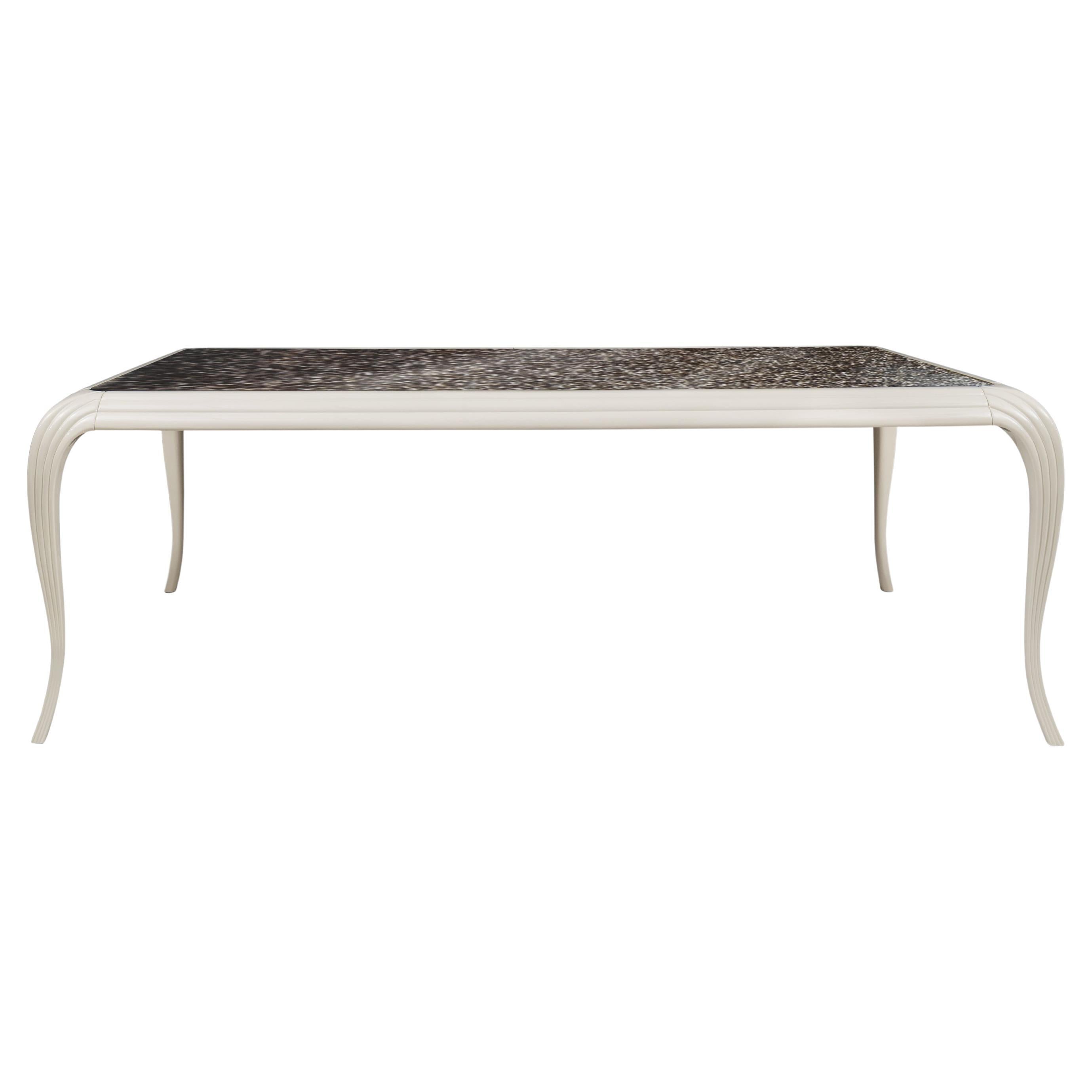 Recevez dans un style haut de gamme avec la table de salle à manger Merveille. Les plumes étonnantes sont magnifiquement présentées sous verre et soutenues par de gracieux pieds laqués arqués. Les invités ne manqueront pas de s'émerveiller devant