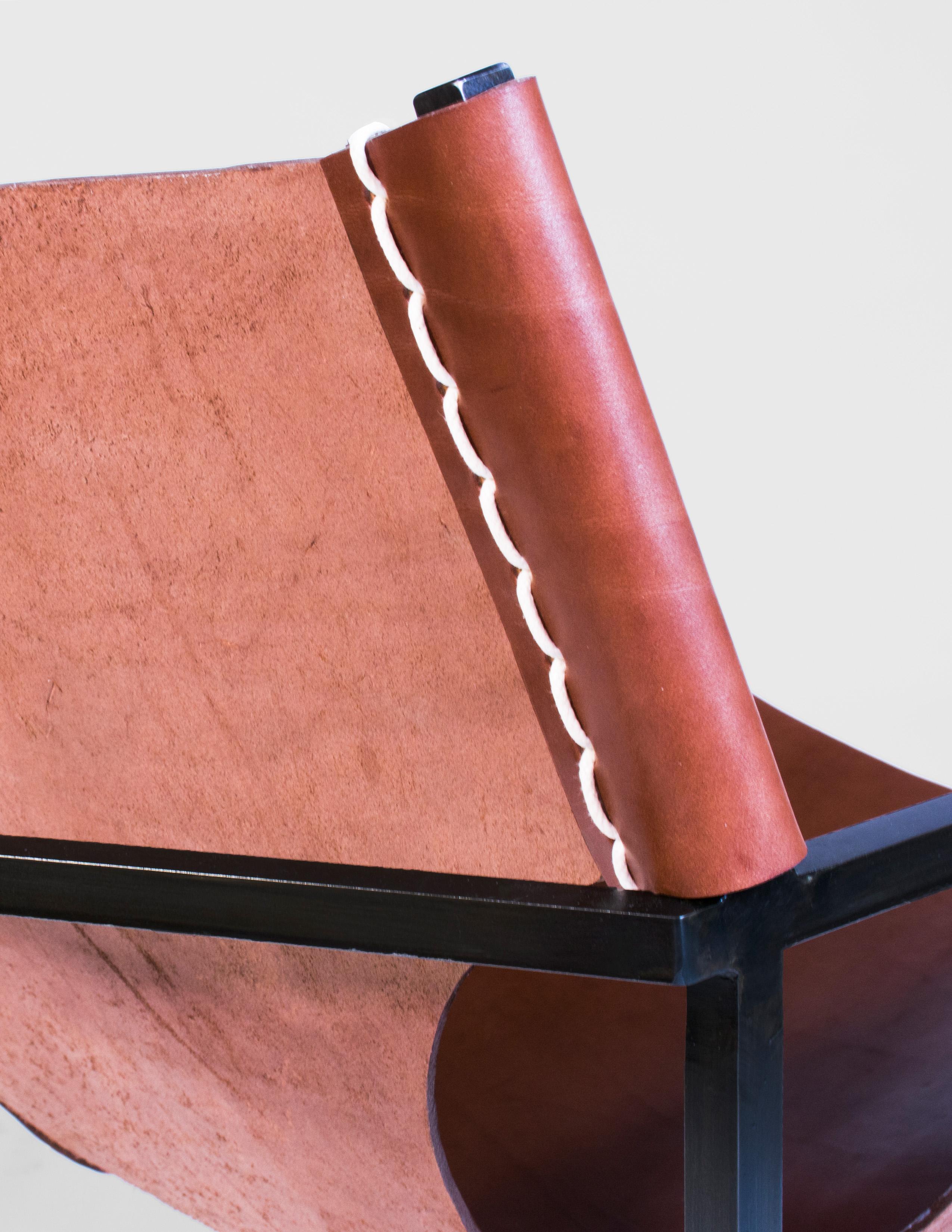 Handgefertigter Ledersessel aus tabakfarbenem Leder, befestigt an einem geschwärzten Stahlrahmen mit schwerem Sattelstich und gehämmerten Messingnieten. Ergonomisches Design für mehr Komfort. Entworfen und hergestellt auf Bestellung in New