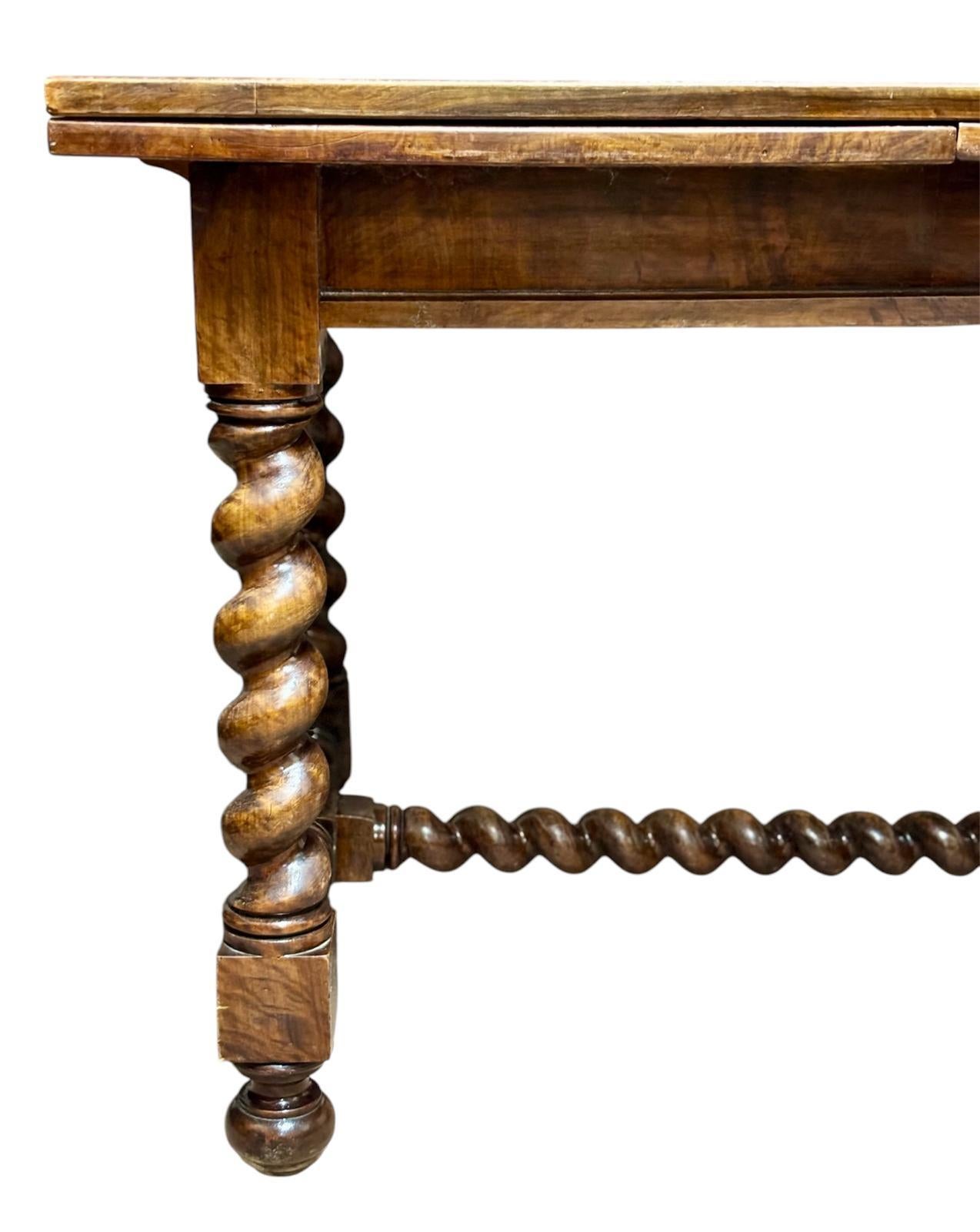 Mesa española extensible Circa 1.880, realizada en madera de nogal teñida, con las patas y el bastidor torneados en estilo salomónico.
