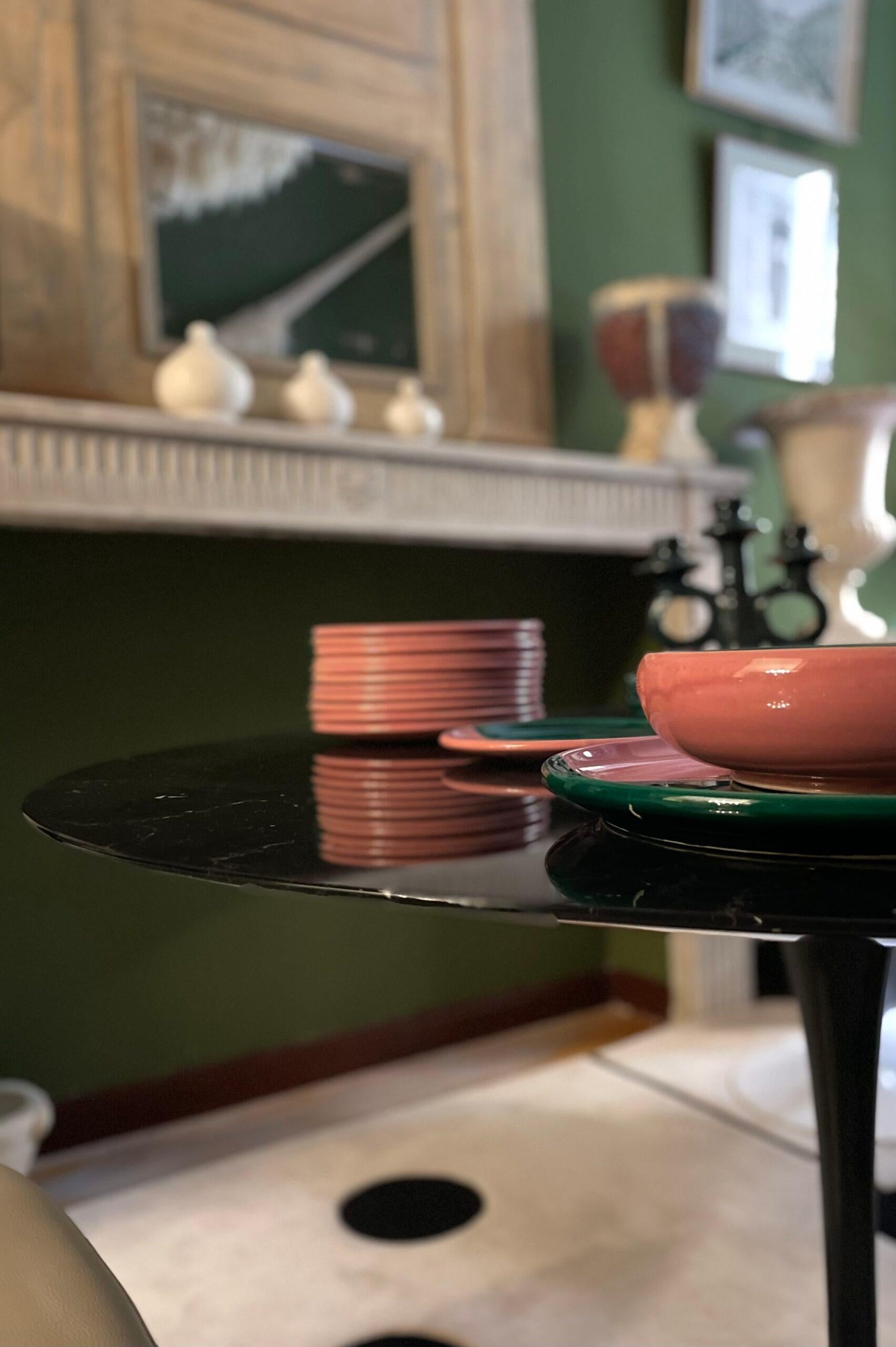 Tulip table by designer Eero Saarinen produced by Knoll. With a marquina marble top with bevelled edge, this table is distinguished by its tulip-shaped leg made of cast aluminium and black lacquered rilsan, an innovative option to traditional table