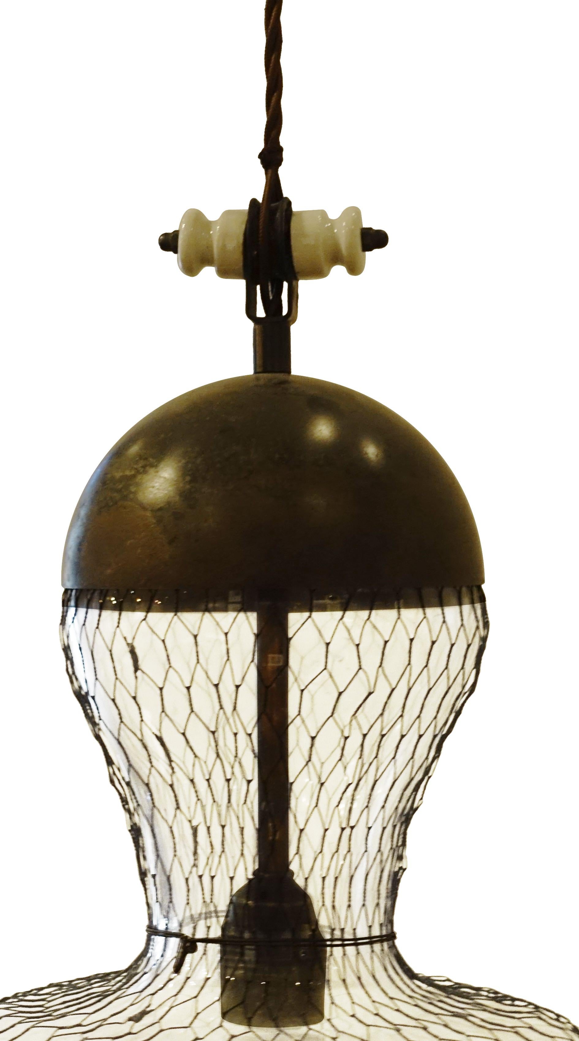 Hour glass shaped glass covered in metal mesh with weathered metal bottom edge and top cap.
Vintage white porcelain decorative detail.
Braided brown silk cord can be shortened to adjust height.
Cap included.
100 watt maximum.
Fixture height is