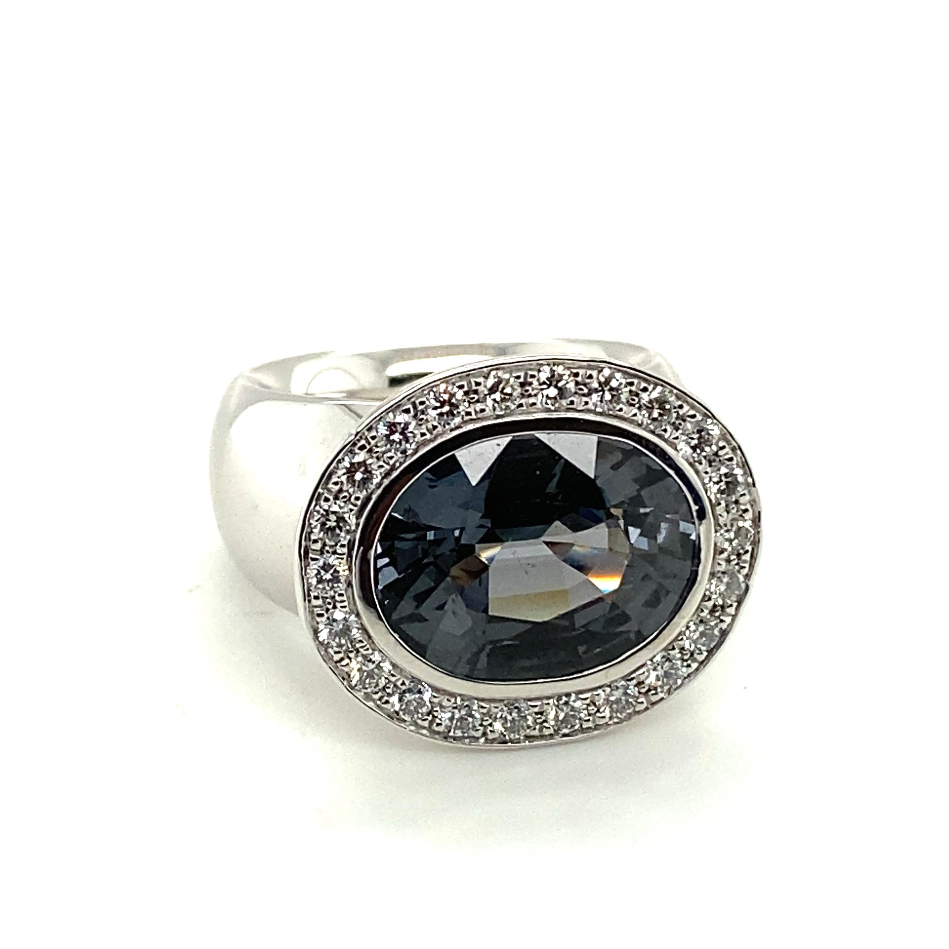 This beautiful handcrafted ring in 18 karat white gold enchants with an 8.84 carat oval-cut sparkling grey spinel. Its fire is further intensified with purple and blue sparkles. A truly unique gemstone!
The spinel is framed by 20 brilliant-cut