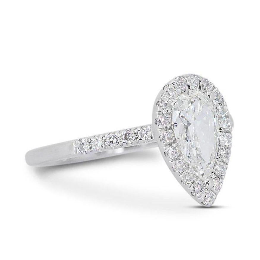 Dieser Ring ist nicht nur ein Schmuckstück, er ist ein bezaubernder Tropfen aus Licht, der Eleganz und Anmut ausstrahlt. Sein Herzstück, eingebettet in glänzendes 18-karätiges Weißgold, ist ein prächtiger birnenförmiger Diamant von 0,75 Karat. Sein