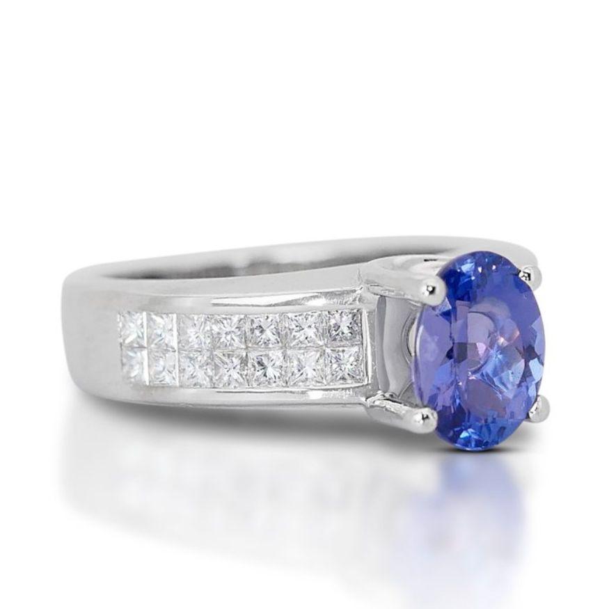 This mesmerizing ring features a stunning 2.00-carat oval mixed-cut tanzanite as its centerpiece, radiating a deep violetish blue hue that captivates the eye. With its transparent clarity, the tanzanite showcases its natural beauty, allowing light