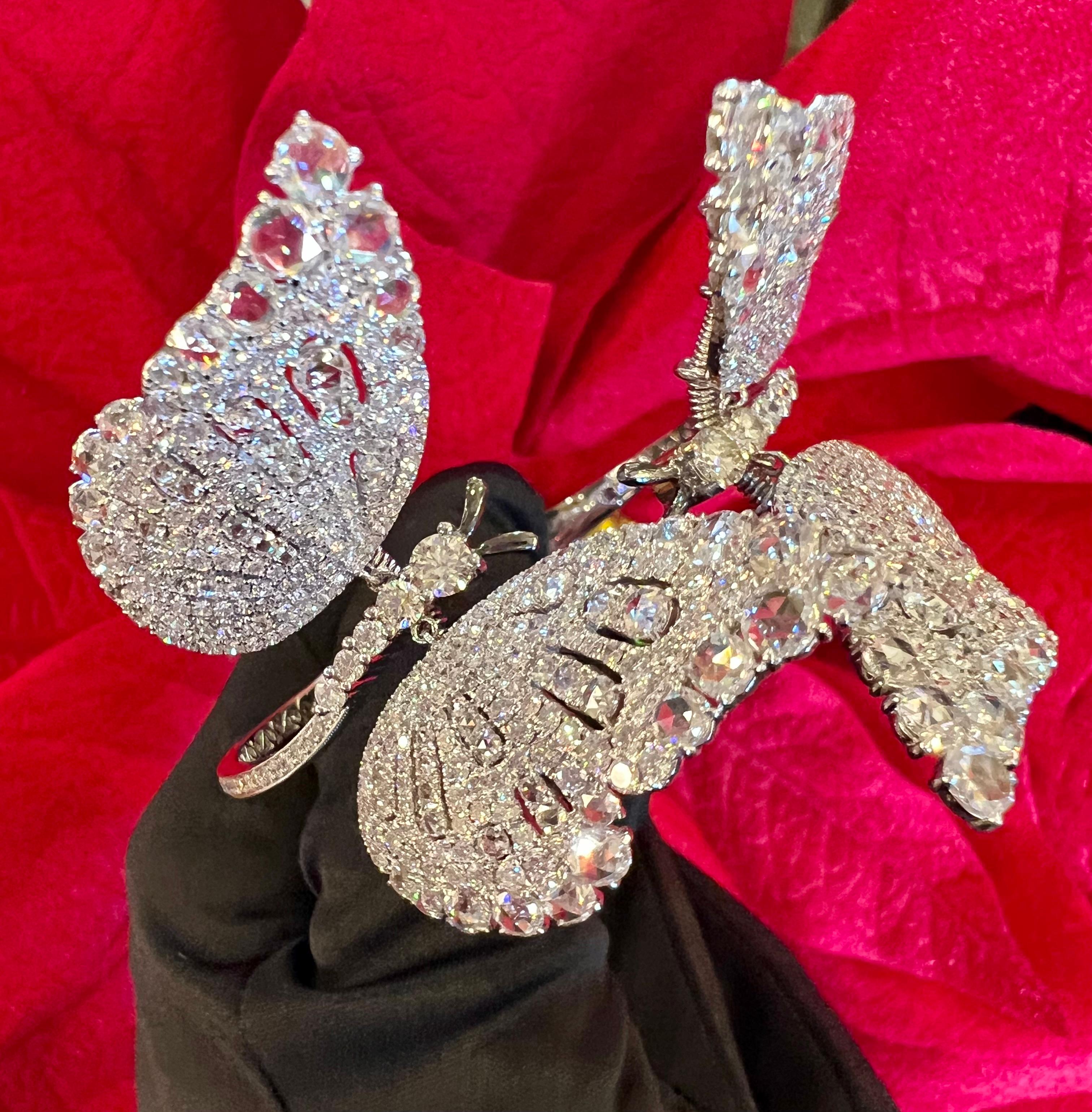 Totally dreamy, hand made, 18 karat white gold hinged diamond butterfly bangle or clamper bracelet features a myriad of the most sparkling diamonds and is a true work of art! Large fluttering wings move with grace giving the appearance the