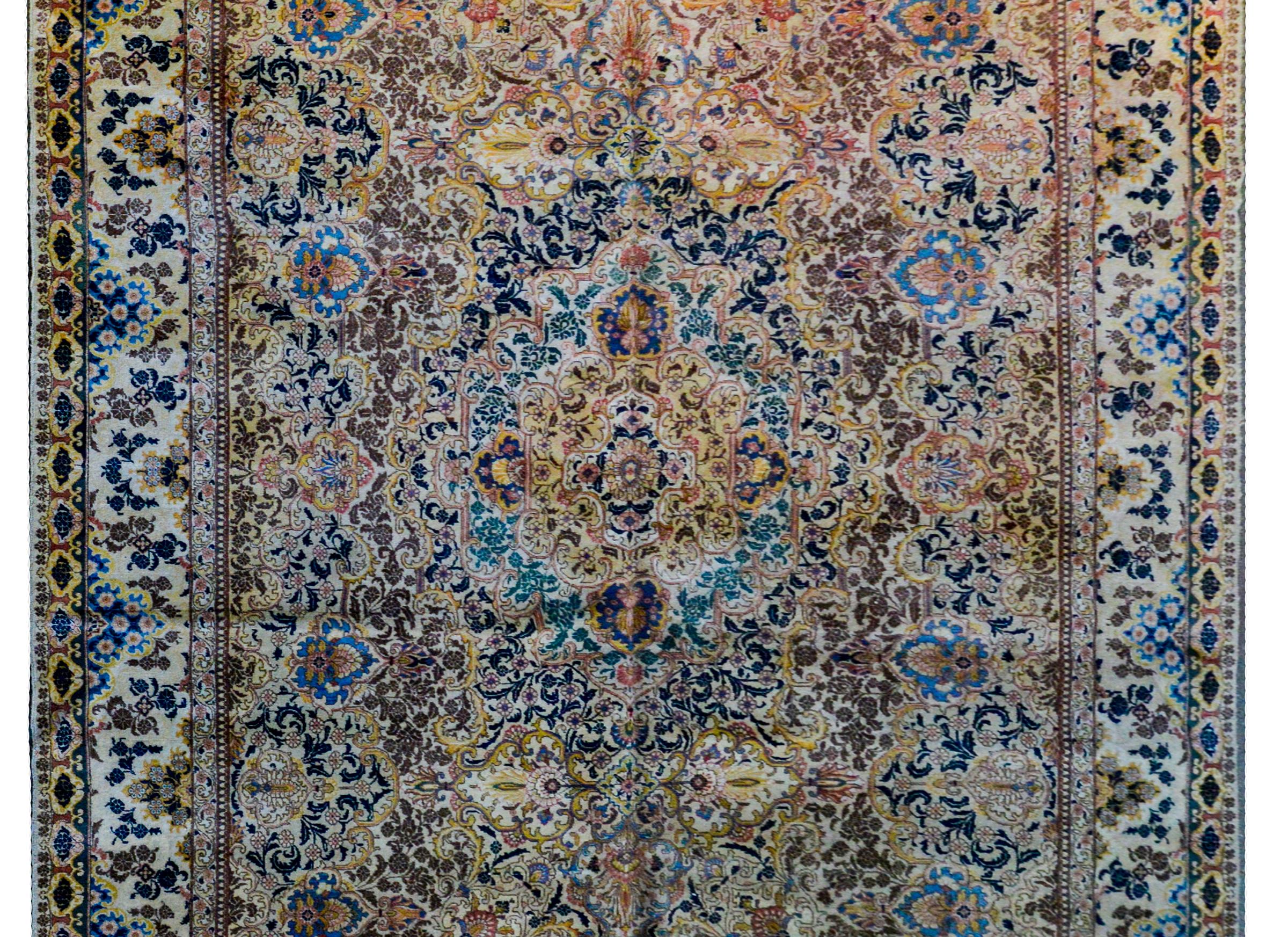A mesmerizing early 20th century Persian Tabriz rug with medallion on top of medallion on top of medallion, each with a myriad flowers and scrolling vines and leaves woven in light and dark indigo, pink, gold, green, cream, and brown vegetable dyed