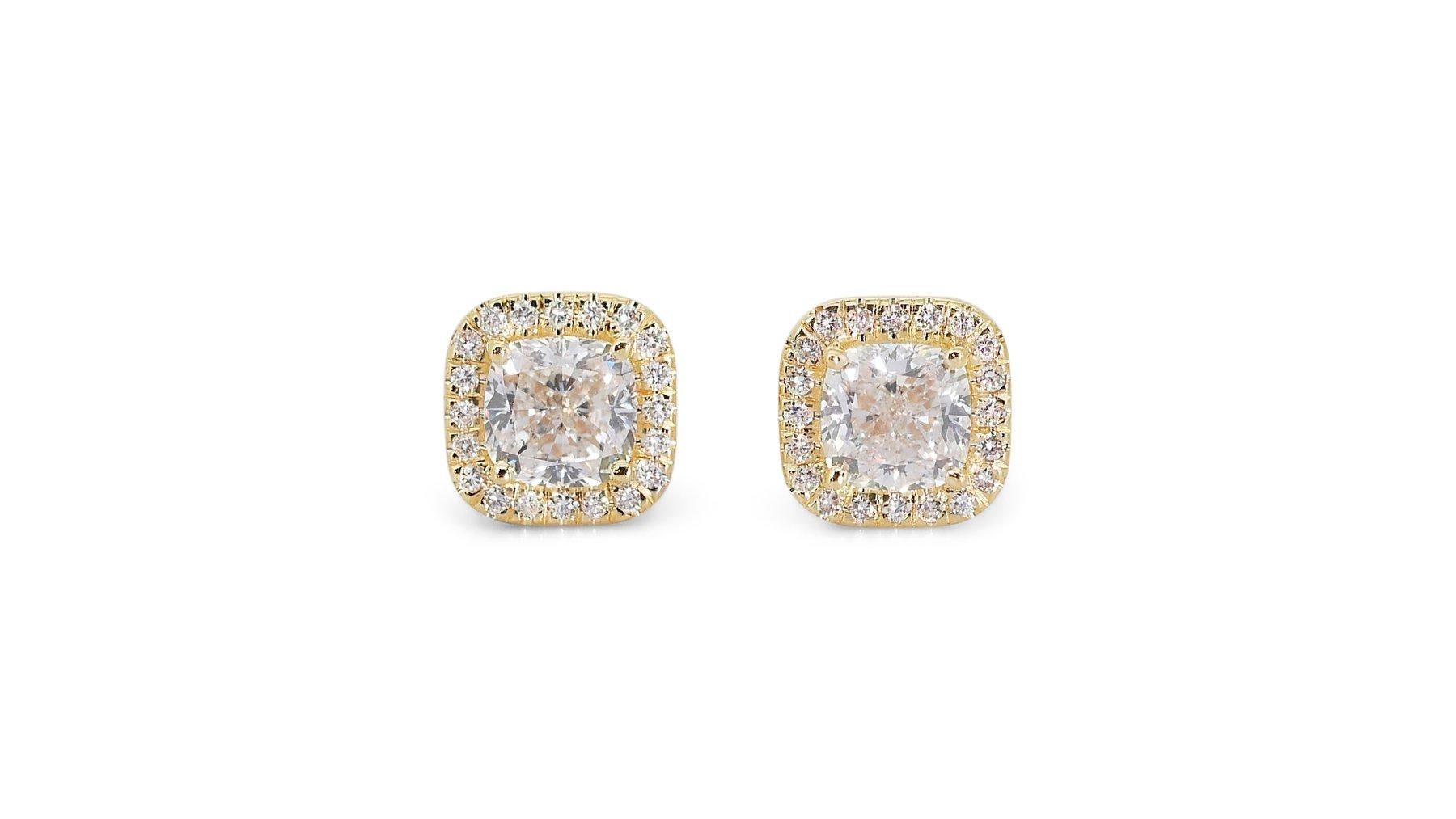 A mesmerizing pair of earrings featuring 3 carat cushion shape natural diamonds, certified by IGI (certificate number 10J2181823). The diamonds have a color of G-H and clarity of SI1-SI2, with a cut grade of VG. The earrings are further adorned with